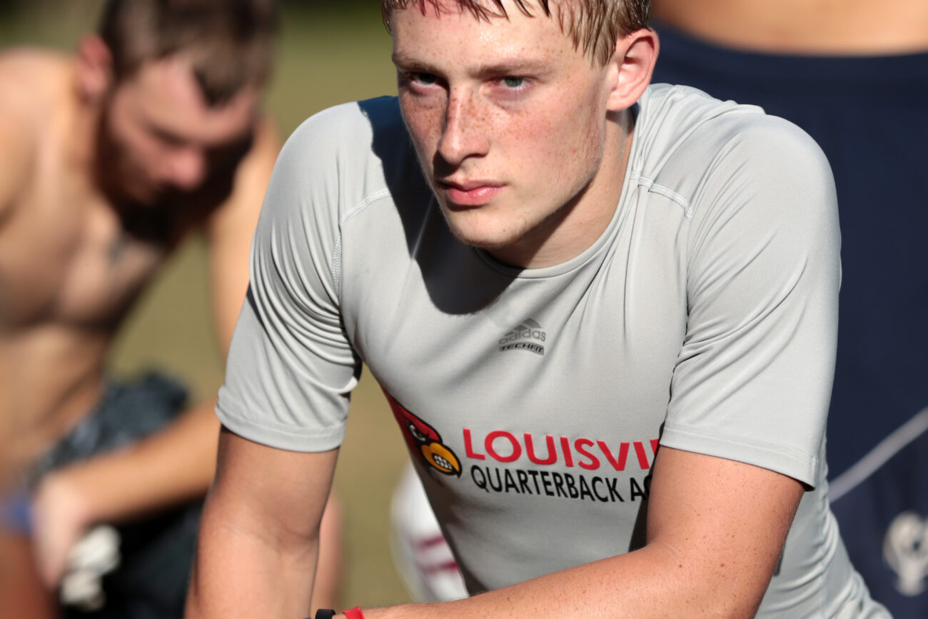 Quarterback Kevin Whitaker, 16, kneels at the end of practice to listen to coach Eddie Melton's closing words at Leslie County High School in Hyden, Ky. on Thursday, October 10, 2013. Photo by Adam Pennavaria