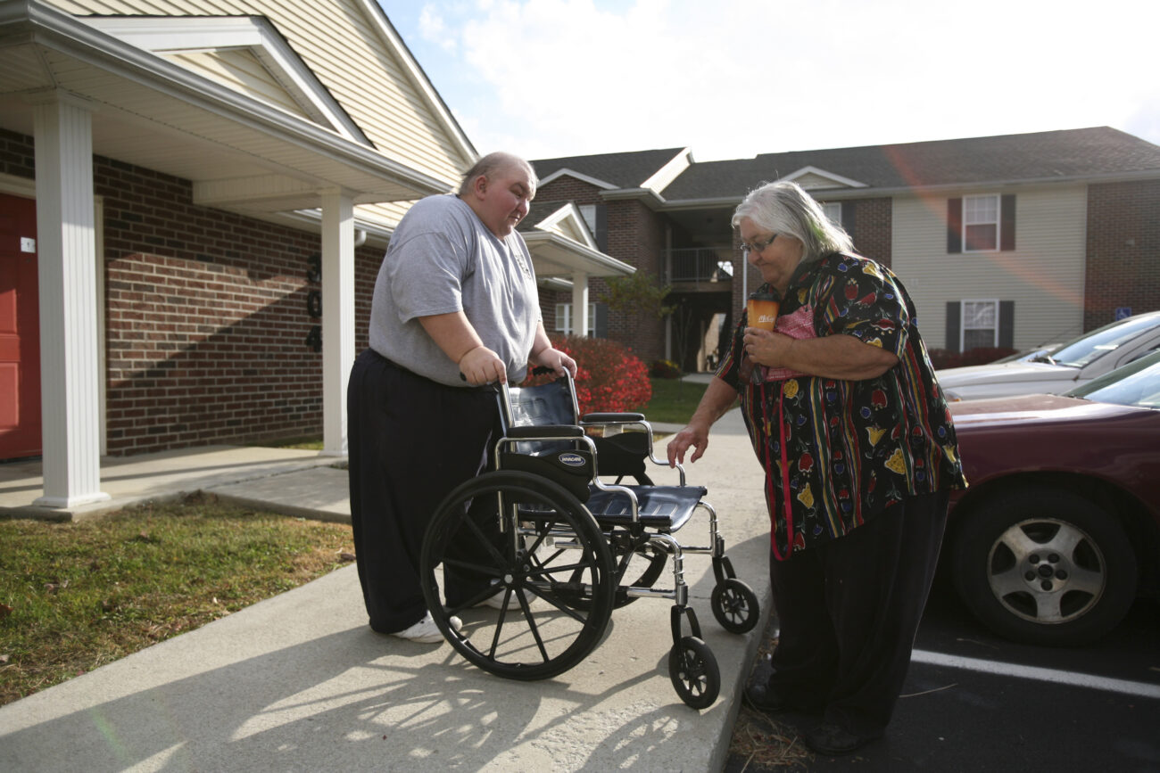 Shannon Caldwell helps his mother, Ruth Caldwell, get into her wheelchair. Although she has health complications of her own, she is a vital part of Paula and Shannon's daily routine as she helps them with tasks they can't do because of their blindness. Photo by Genevieve Adams