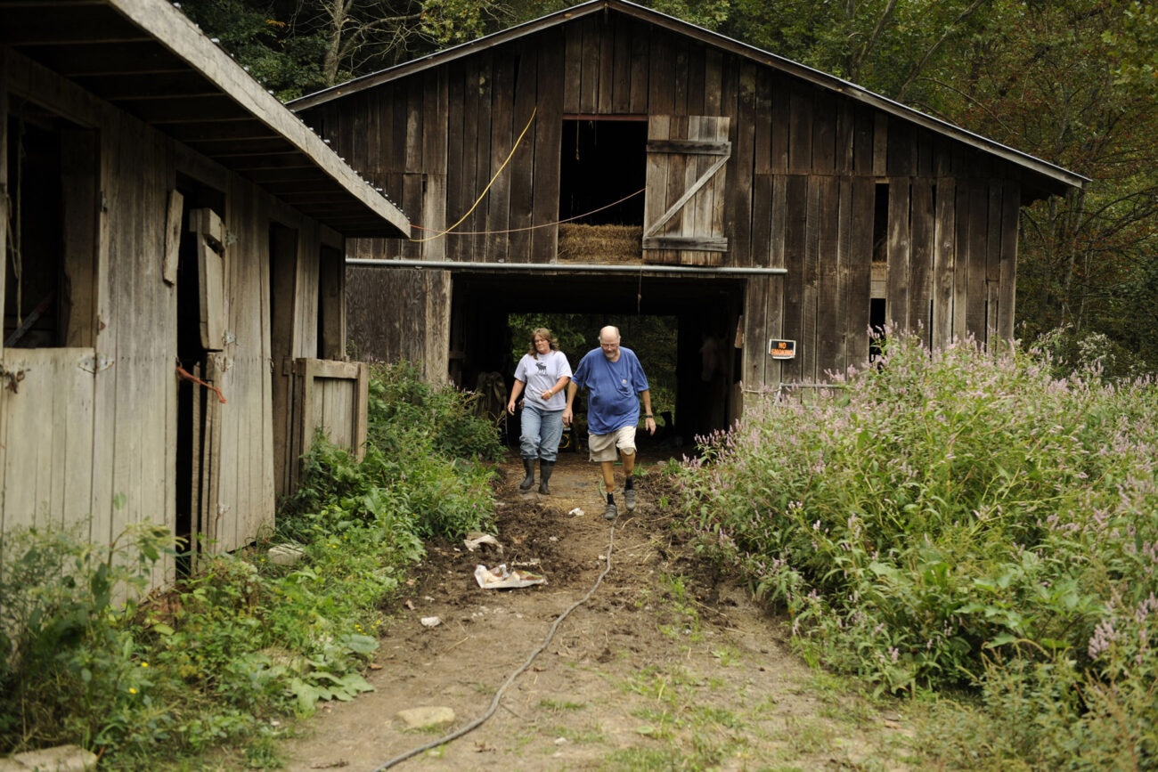 Jim and Charlene walk back to their house from one of their barns after feeding horses. Charlene is often several steps in front of Jim.