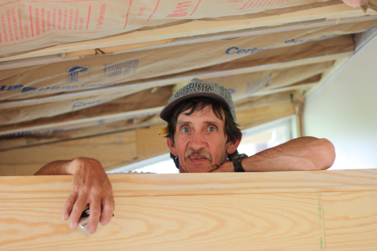 Moses Owens looks over the wall of the extra room being built in Robert Young's house. Photo by Megan Hurt | Picture Kentucky 2009