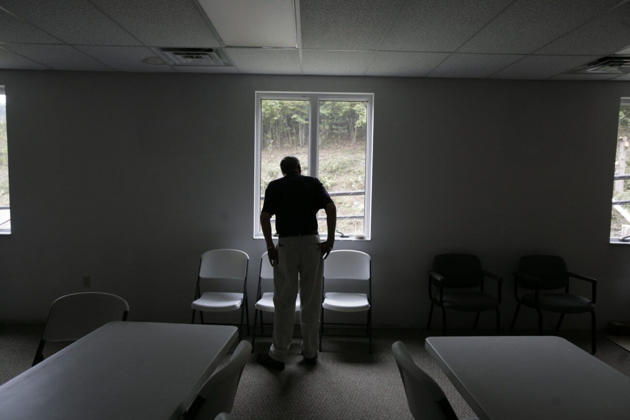 Bob Thacker watches from the second window of his office building as a crew clear trees from behind the property on Thursday, Sept. 17, 2009.