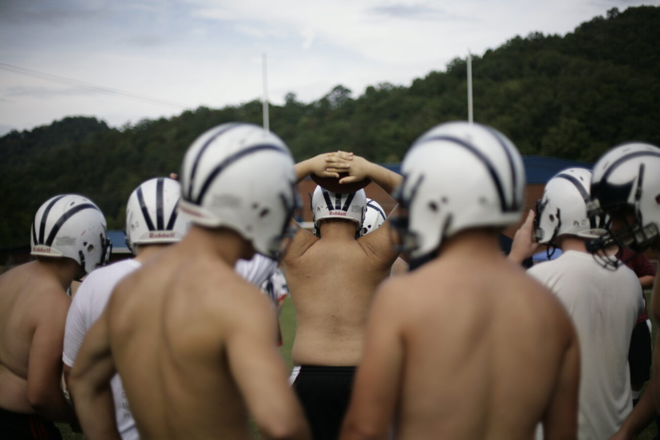 Members of the Knott County Central High School football team listen as their coach explains a play at practice on Thursday, Sept. 17, 2009.