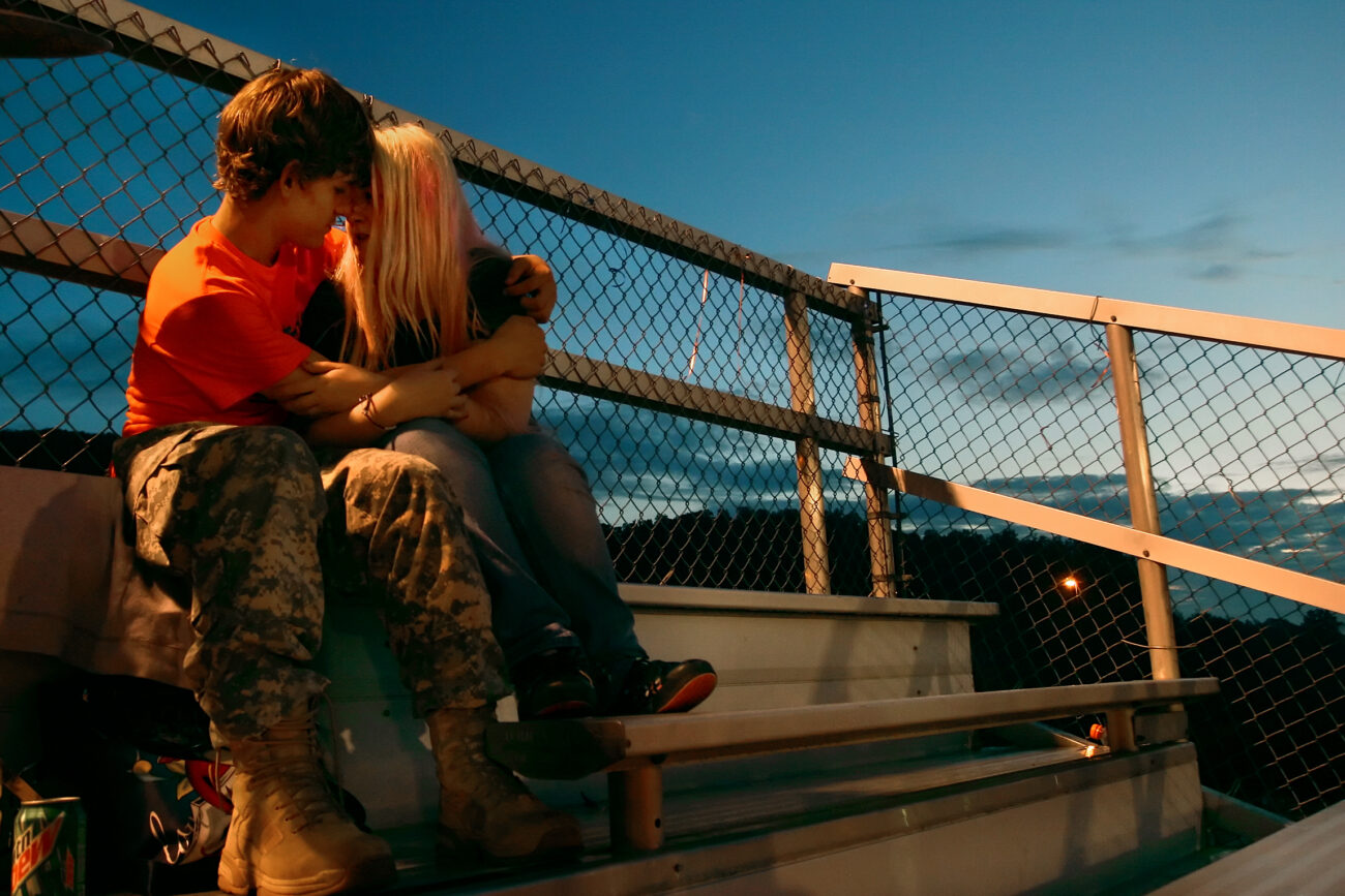 Dylan Parks, 14, and his girlfriend of nine months Angelica Moore, 15, cuddle on top of the bleachers at Pike County Central High School during the football game against Knott County Central High School.