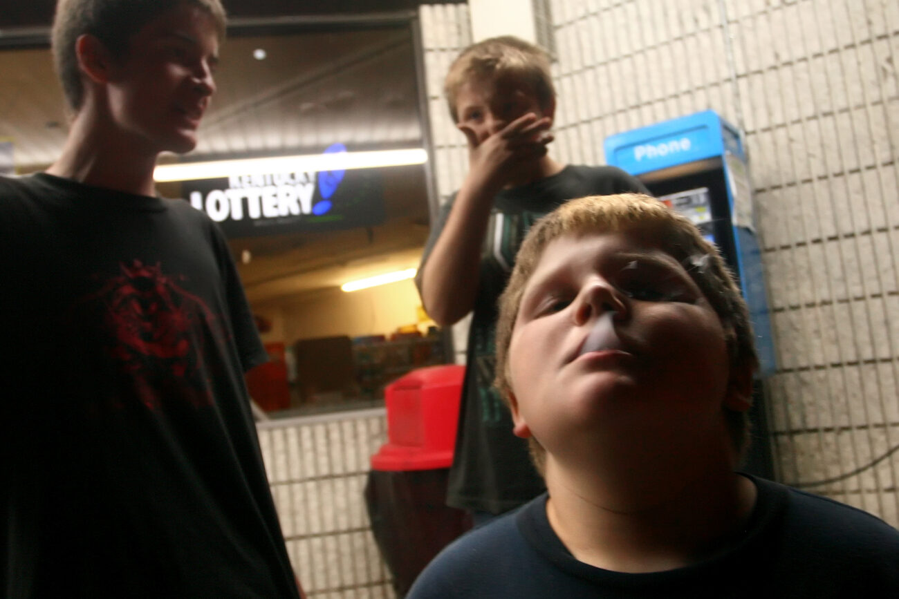 William Slone, 11, french inhales from a cigarette while hanging out with his cousin Johnthan Everage, 11, and Joseph Short, 13, outside of the Mi-Dee Mart after midnight in downtown Hindman, KY. "There isn't much to do in Hindman," says Short.