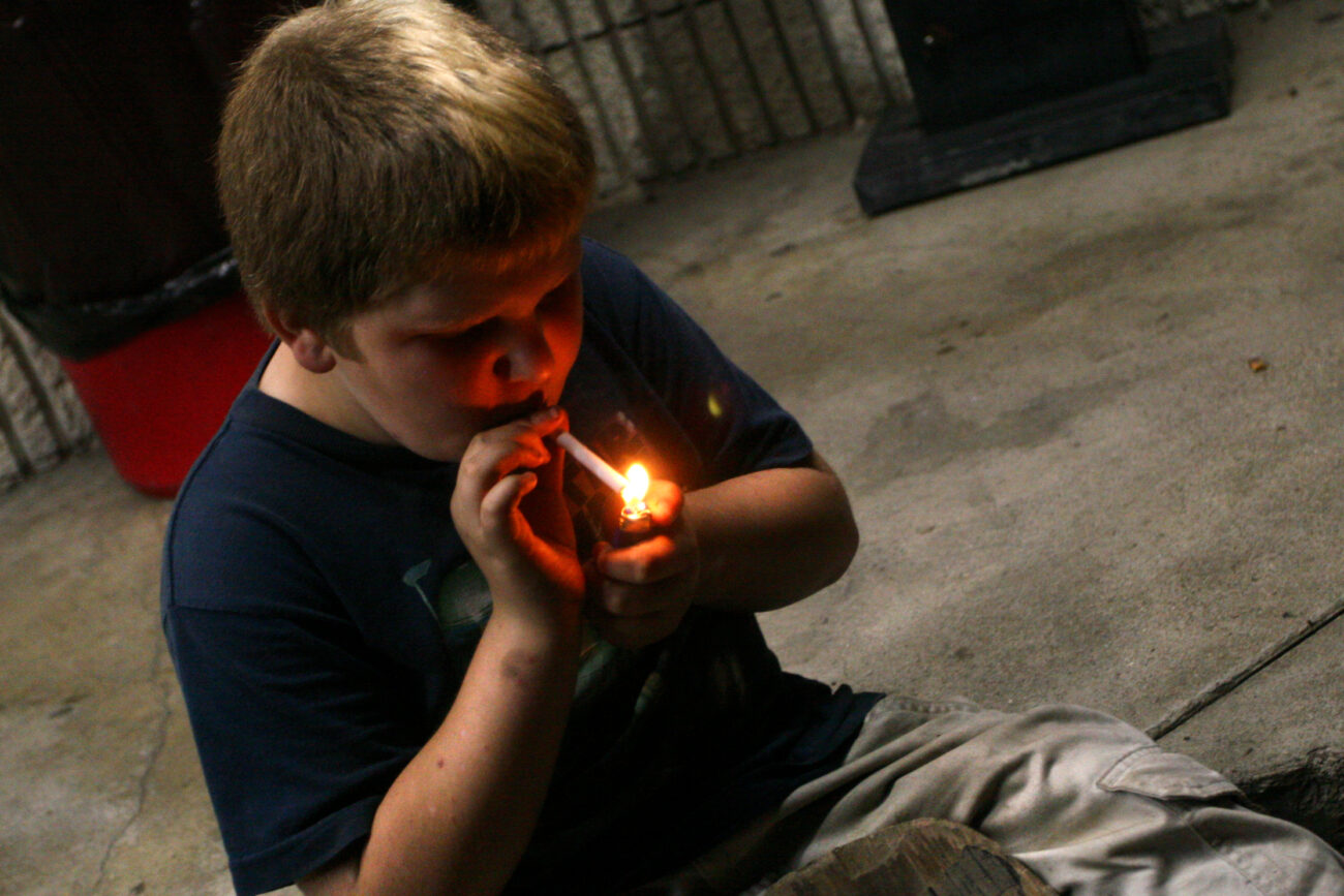 William Slone, 11, smokes a cigarette outside of the Mi-Dee Mart in downtown Hindman, KY. "It's already lit so I might as well," Slone responds when his mother scolds him for smoking.