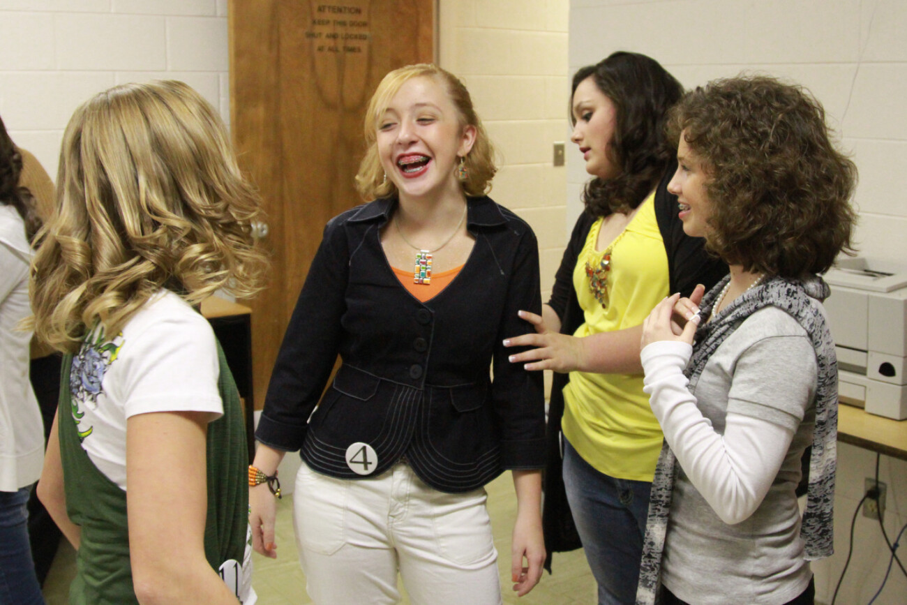 Before the start of the Woolly Worm Princess Pageant, Gabby laughs with some of the other girls in her class backstage. "We all get along real well," Gabby said. Photo by Brandon Goodwin