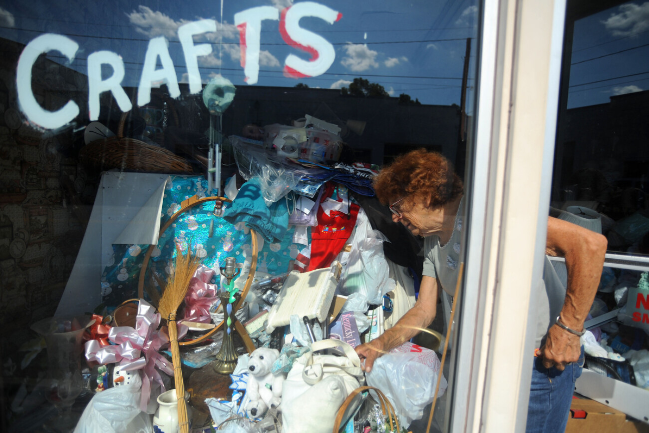 Martha Holland looks for items to put on the sale table outside of her store in Beattyville, Kentucky, September 29, 2010. Since the death of her husband Vincent in 1996, she has slowly filled her store with so many things she is unable to walk past the opening of the door.  Photo by David Foster