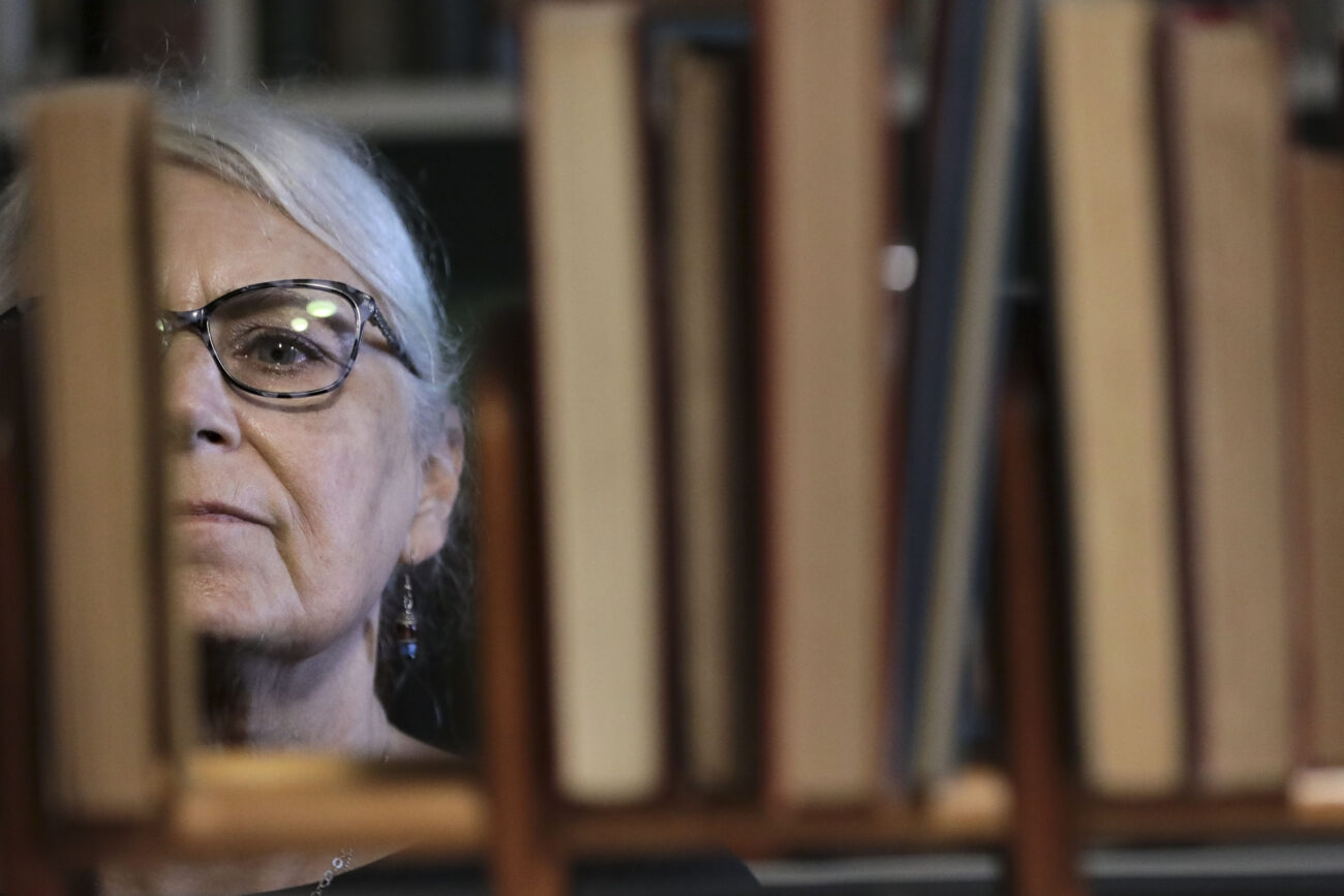 Lizz Taylor, owner of Poor Richards Books, looks for books out of alphabetical order in Poor Richard’s Attic in Frankfort, Kentucky, on Thursday, Oct. 14, 2021.