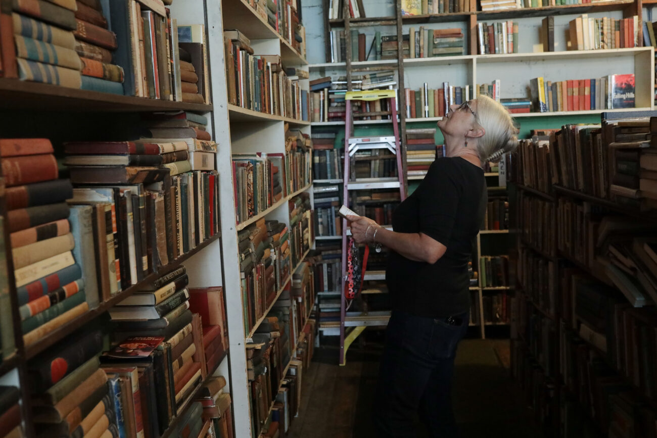 Lizz Taylor puts books into their correct places in Poor Richard’s Attic in Frankfort, Kentucky, on Thursday, Oct. 14, 2021.