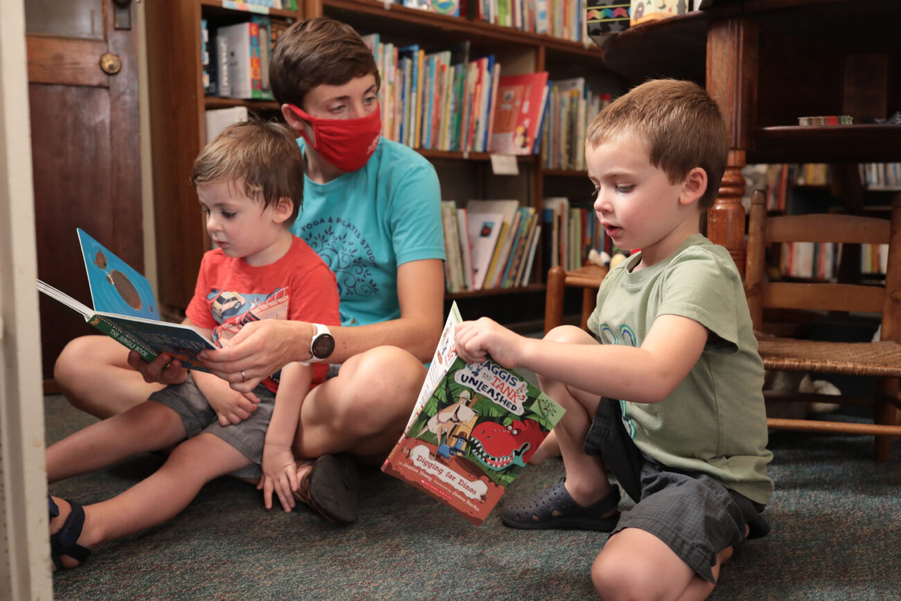 Grace Rogers, middle, and her children Henry, right, and Leo read on the floor in the children’s section of Poor Richard’s Books, on Thursday, Oct. 14, 2021.