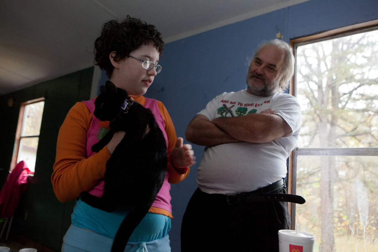 Marylynne Hall, 13, and her father Joseph smile as they enjoy time as a family in one of two trailers that Joseph and his sister Donna have purchased for their two families to live side by side. Both families have been homeless in recent months.