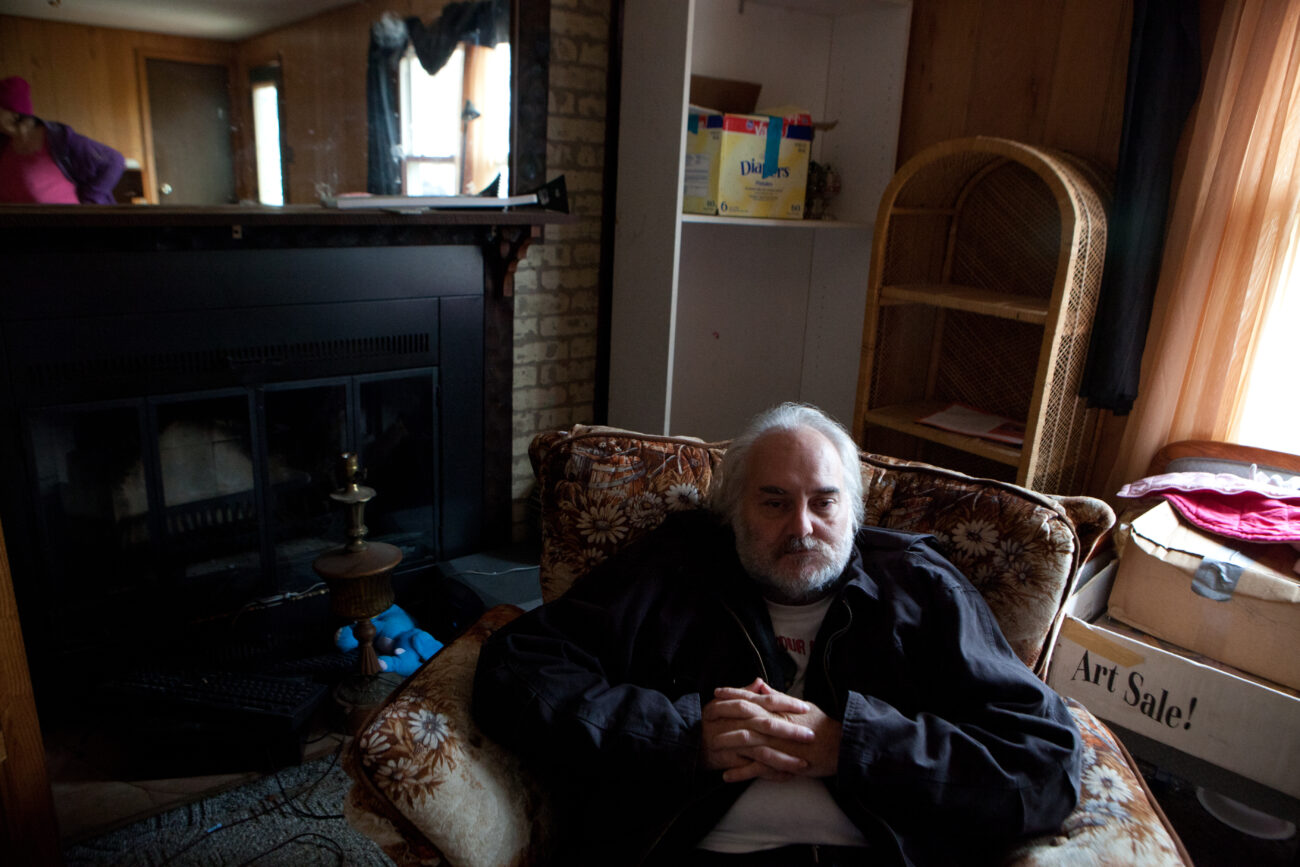 Joseph Hall sits for a moment in his armchair in his family's new trailer. The Halls have been homeless for two and a half months while Joseph has worked to purchase land and trailers for his family and his sister's family, and set up both with water, sewage and power.