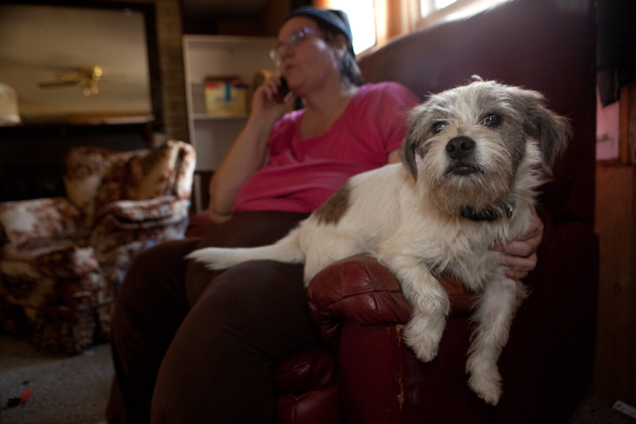 Donna Hall sits with the family dog, Zipper, who is trained to work with children with autism. Donna and her brother Joseph each have an child on the autism spectrum, and both families have been homeless in recent months. The siblings are moving their families into trailers next to each other on a lot in London, KY.