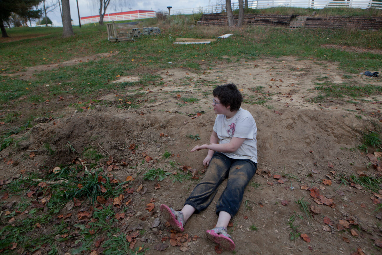 Marylynne Hall, 13, plays in the dirt outside her family's new home. After being homeless for two and a half months, the Hall family is about to move into a trailer.