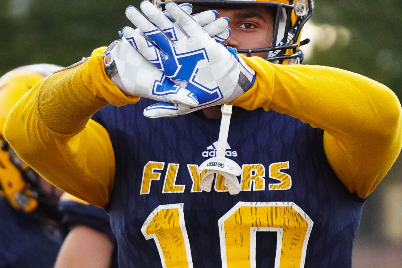 Kaden Moorman flashes his UK football gloves as he walks onto the field for the homecoming night football game in Frankfort, Kentucky, Friday, Oct. 15, 2021. Moorman is a running back in his junior year for his high school team, the Franklin Flyers, and has committed to play football for the University of Kentucky.