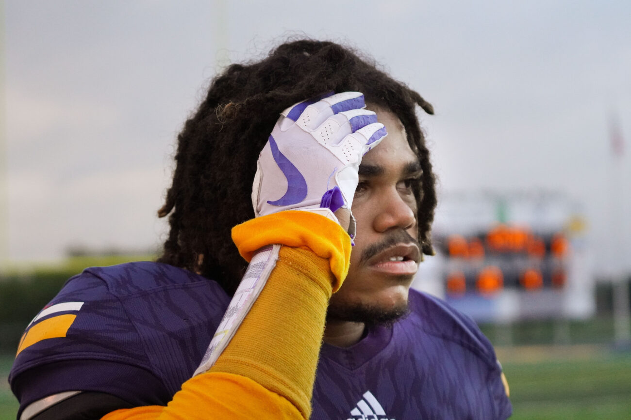 Kaden Moorman rubs his head as he stands on the sidelines in Frankfort, Kentucky, Friday, Oct. 15, 2021. Moorman was sidelined after a play, and was evaluated by the trainer. He was taken out of the game because of a possible concussion.