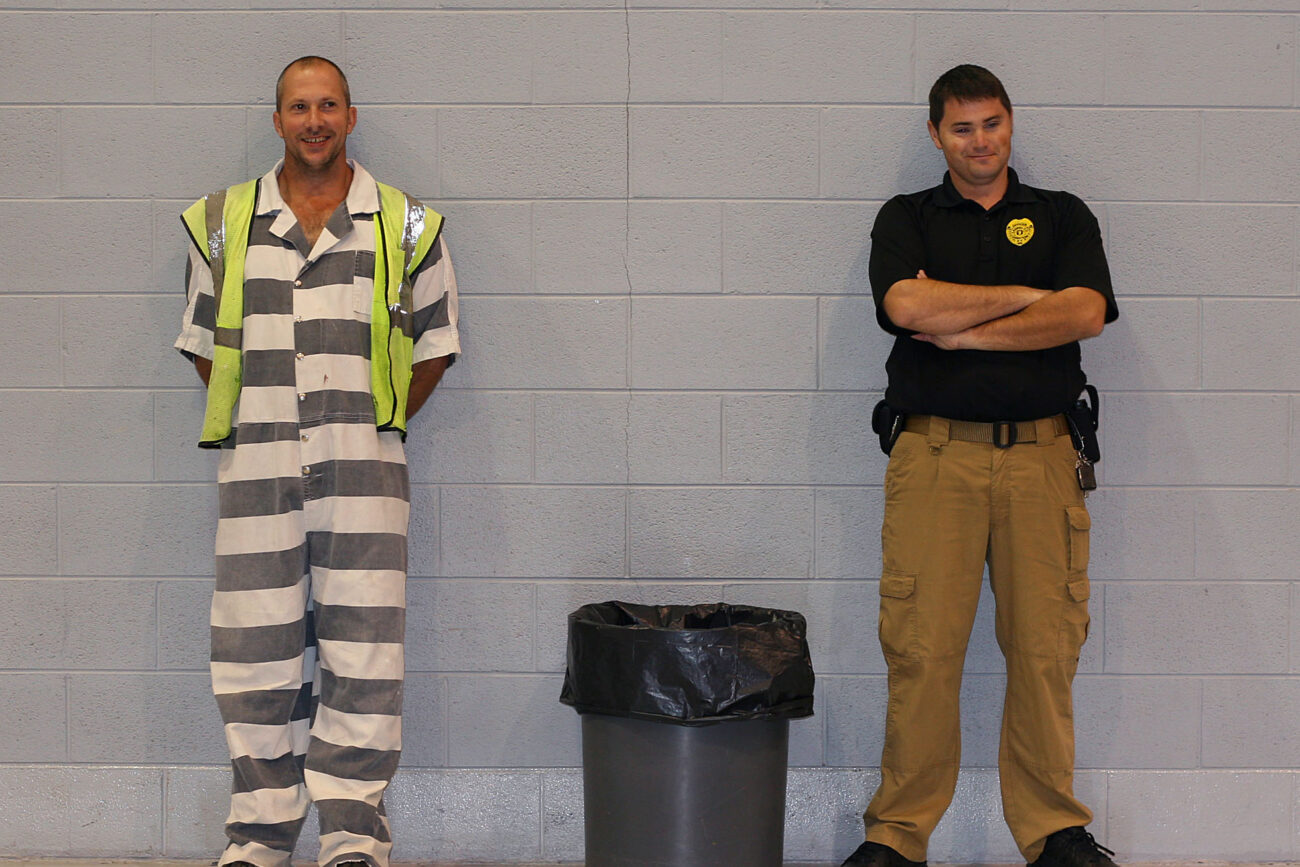 Sam Owens and his corrections officer Billy King take a short break while setting up for an auction at Laurel-London Optimist Club, a nonprofit activity center for children. The inmates generally work there Monday through Friday on work release. Their tasks can include cleaning up the gym after a game or repainting the soccer and baseball fields..Photo by Amanda Powell