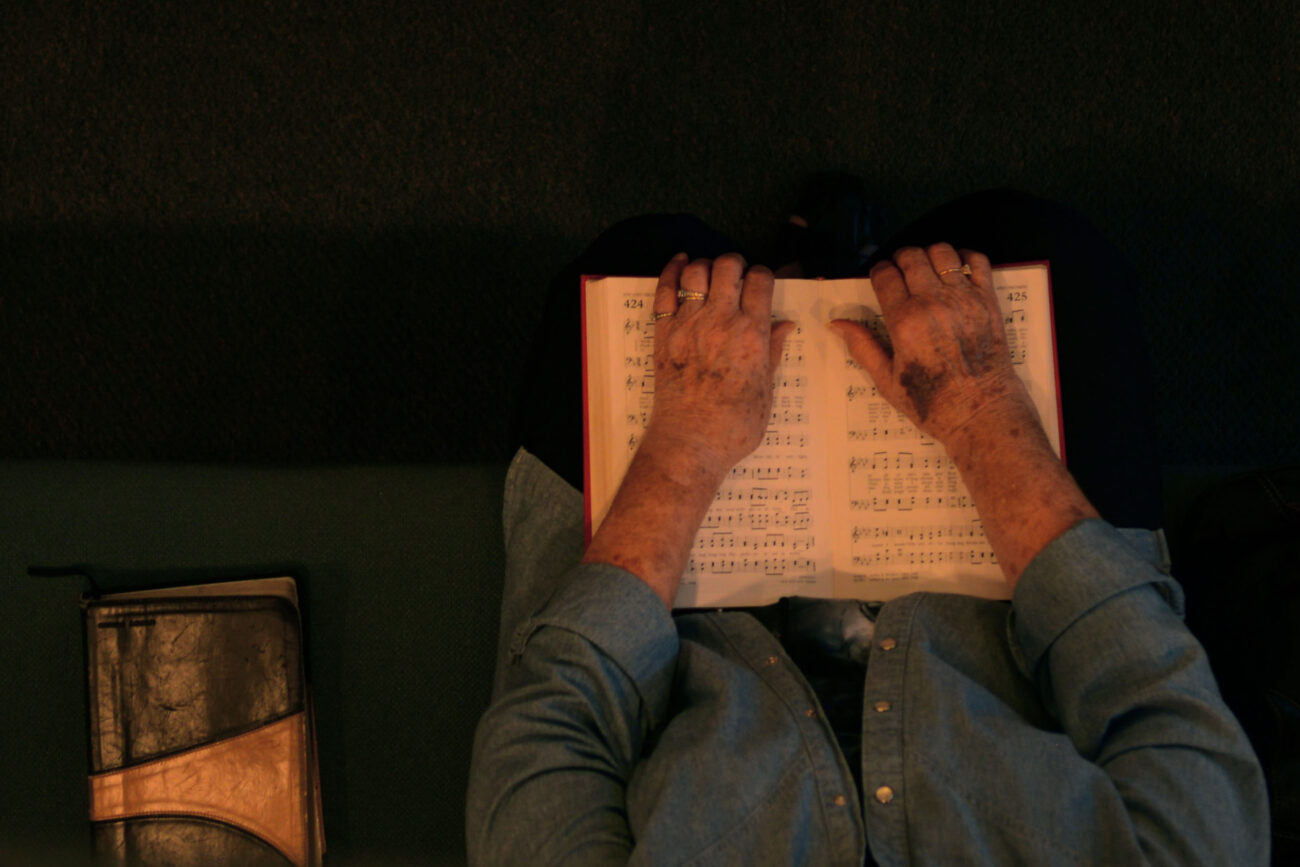 A women clutches her hymnal during a Wednesday prayer service at Hyden Baptist Church in Hyden, Kentucky, Wednesday, Oct. 9, 2013. Photo by Leah Klafczynski