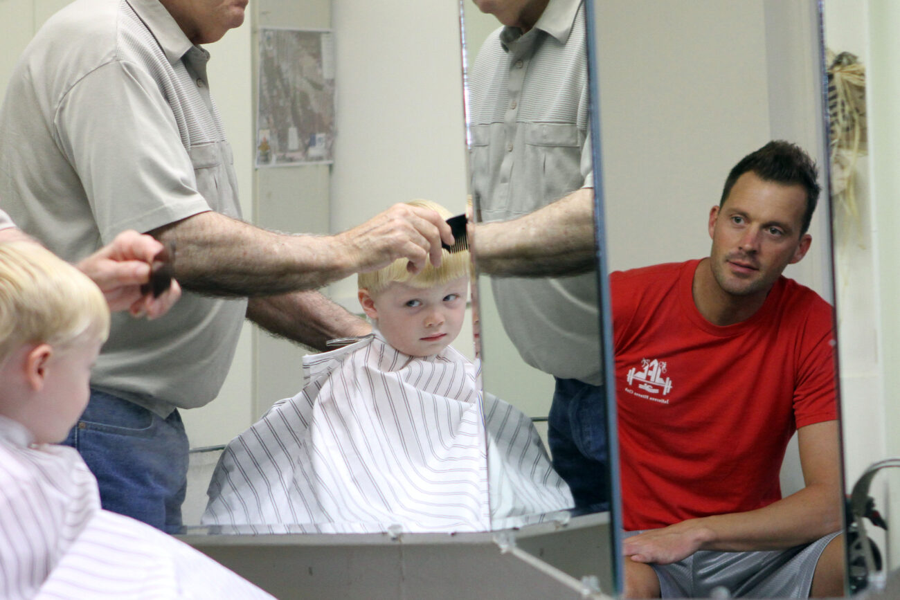 A father watches his son get his first haircut by Jim, owner of the barbershop. Photo taken at Jim Cloud Barbershop in London, Ky. on October 26, 2012. Photo by Quianna Lige