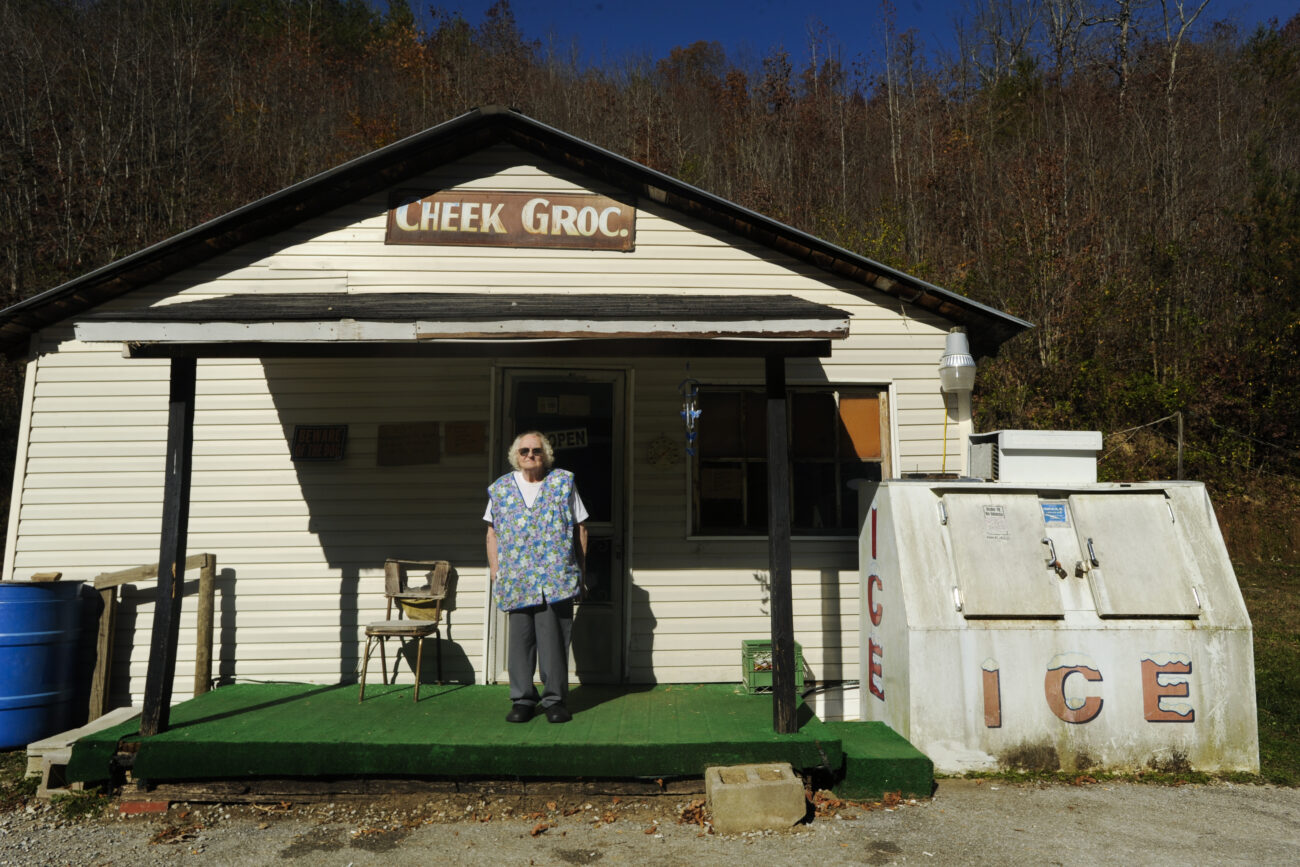 Hazel Cheek, 80, stands on the porch of her 20-by-20-foot grocery store on Pistol Creek Road. Cheek has been running the store for 32 years and sells items like bread, cigarettes and soda. She started holding a church service inside every Sunday after she survived kidney failure, heart surgery and a stroke. "It ain't my store anymore. It's God's store," she said. "He's brought me a long way."