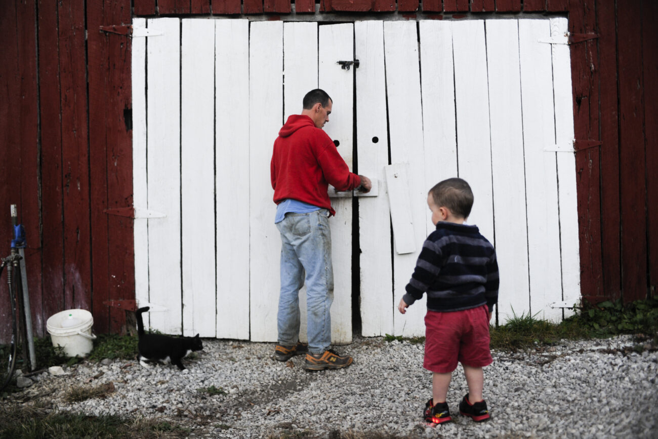 Ford Waterstrat opens the door to his barn with his son Finley, 2, on his organic farm in London, Ky., on Thursday, Oct. 25, 2012.
