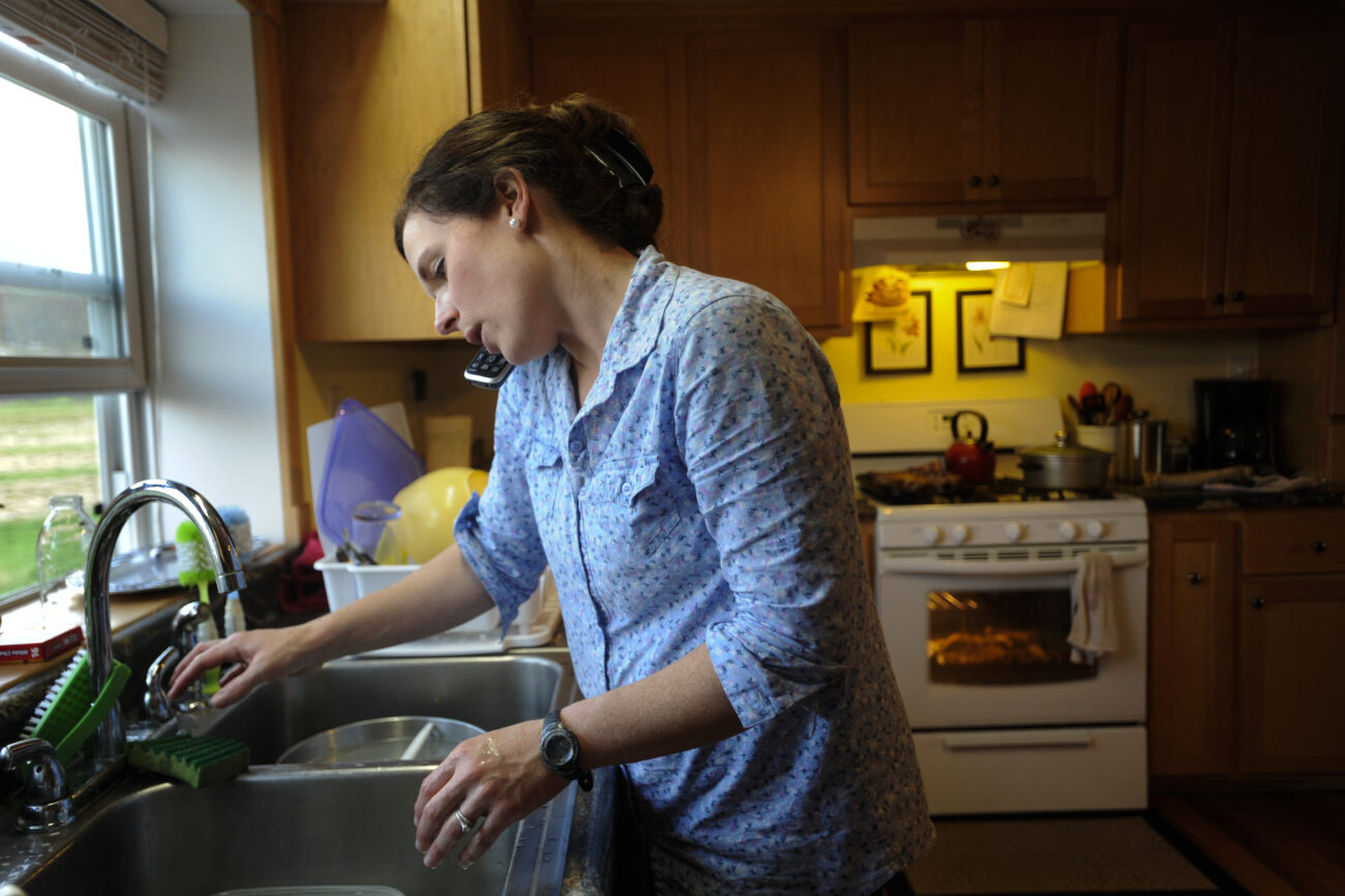 Amanda Waterstrat washes the dishes, talks on the phone, babysits and cooks dinner for the family on the evening of Friday, Oct. 26, 2012. Waterstrat said she used to not understand why men always worked outside while women worked in the house, but when her family started she said it just kind of happened.