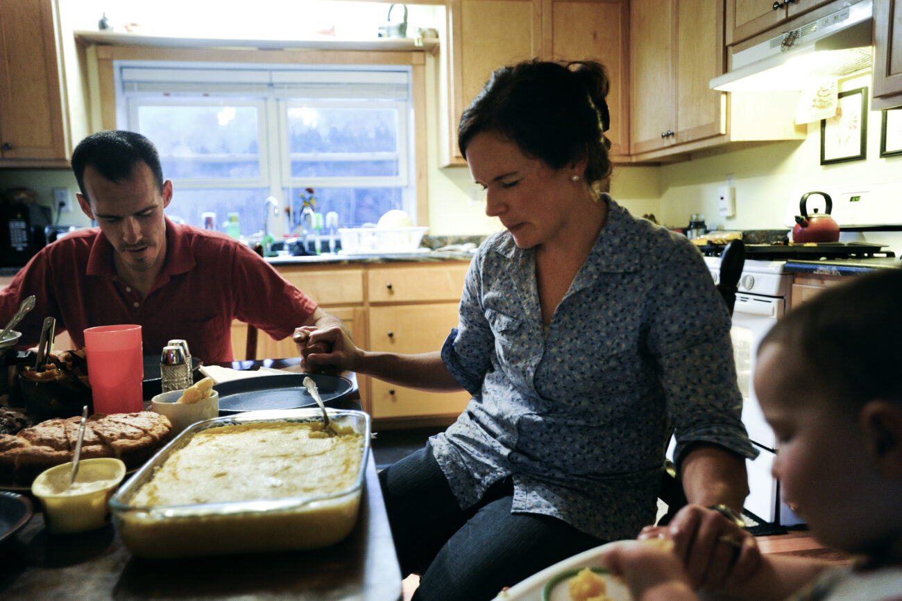 Ford, Amanda, and Finley Waterstrat pray before the evening's meal. Ford said that his faith has helped him with raising Finley.