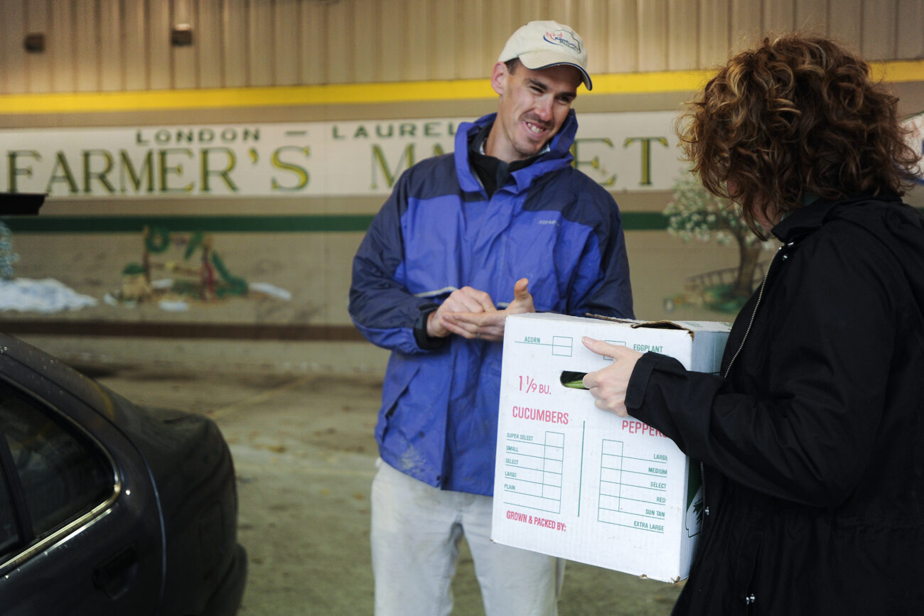 Ford Waterstrat sells a box of his CSA organic vegetables to his weekly customer Jennifer Melton at the last farmer's market of the year in London, Ky., on Saturday, Oct. 27, 2012. Waterstrat prepares each box for specific customers who pick them up at the market each Saturday. Waterstrat and his wife Amanda are going on their third year as CSA-certified organic farmers.