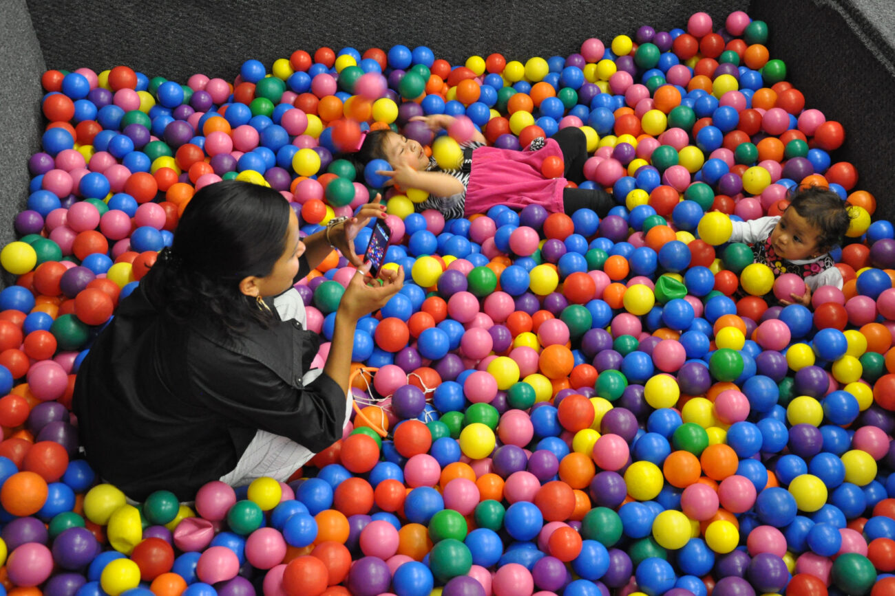 Mimi Ocampo takes a picture of her younger daughter, Meli, in a ball pit at a birthday party for a friend's daughter in London, Ky., on Thursday, Oct. 25, 2012. Ocampo took Meli and her other daughter, Naomi, to the party. Her son, Ozzi, spent the night with his dad, whom Ocampo is separated from. | Photo by Taylor Moak