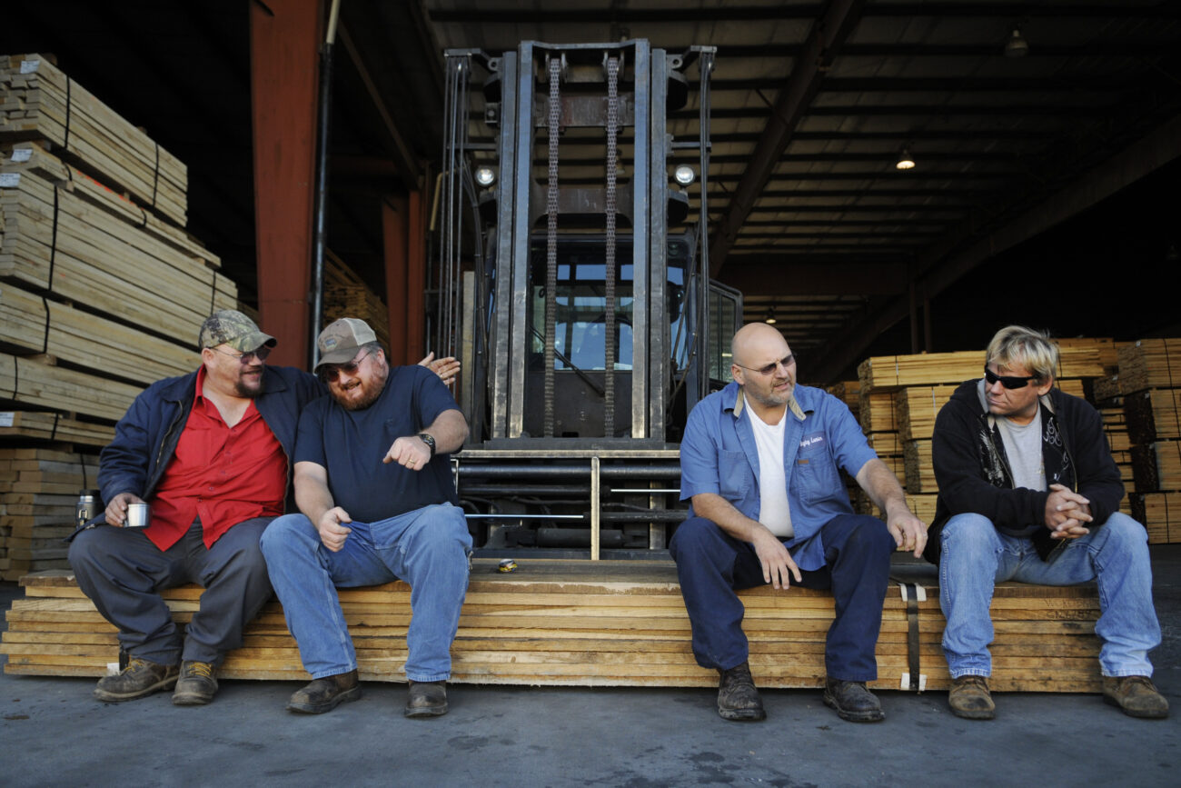 Forklift drivers Jeff "Beaufort" Collins, left, Bruce "Cockeye" Harris, Ricky "Spanky" Smith and Darrell "Hairball" Gray laugh and converse during their morning break at Begley Lumber Thursday morning. Some of these men, along with many of their coworkers at Begley, never finished high school.