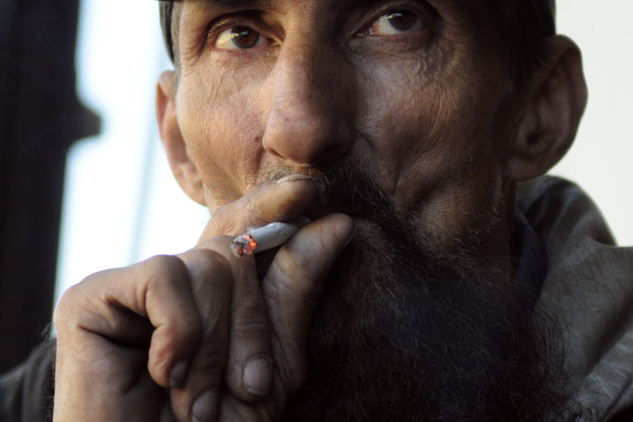 Ronnie "Bin Laden" Jones, 53, smokes a cigarette during a break Thursday morning. Jones, or "Gentle Bin" as he is known around the lumberyard, only completed an 8th grade education. He left school to help make money to support his family.
