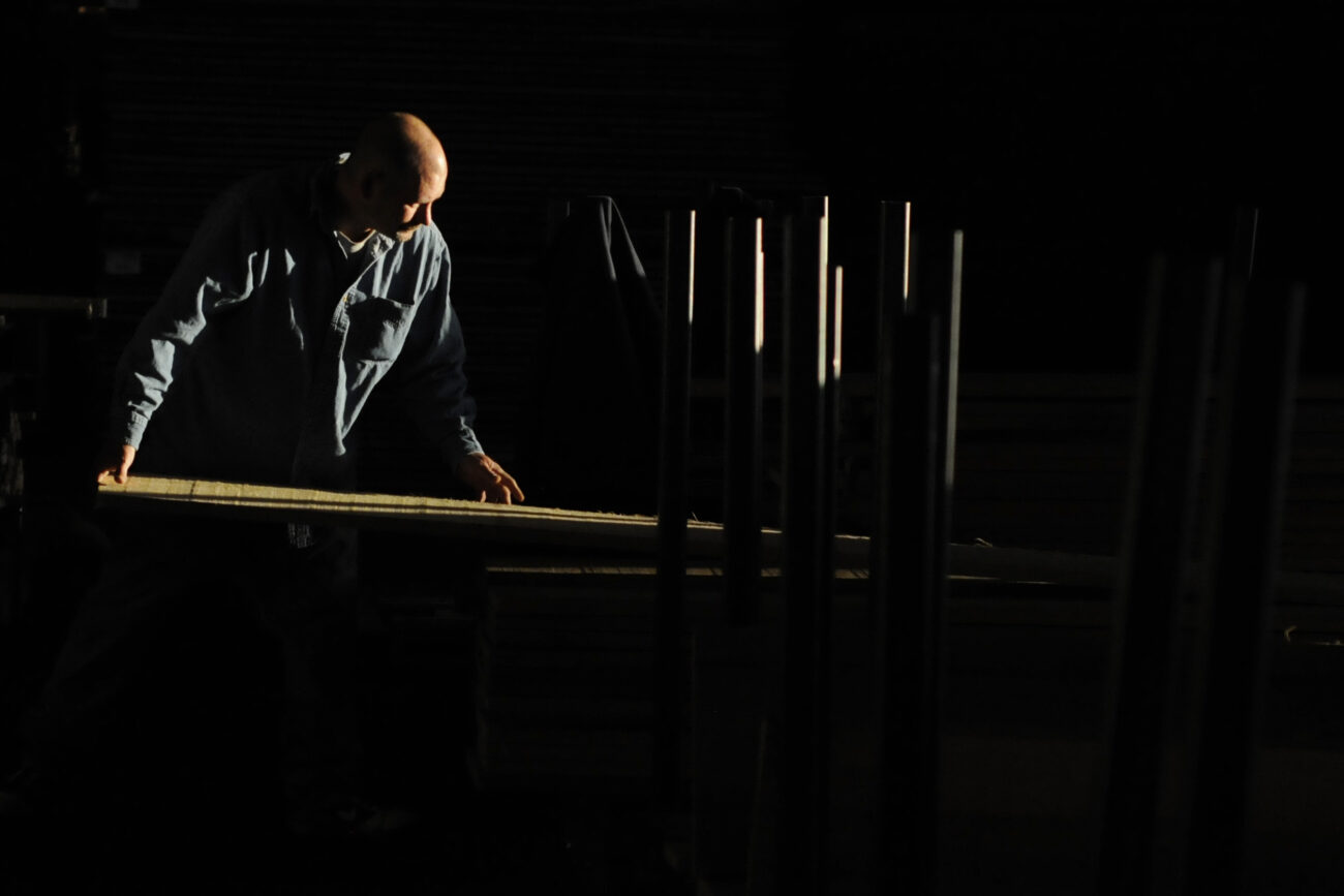 Lumber "puller" Terry "Duke" Smith, 41, sorts lumber by length and grade in the morning sunlight inside the line warehouse at Begley Lumber Friday morning.