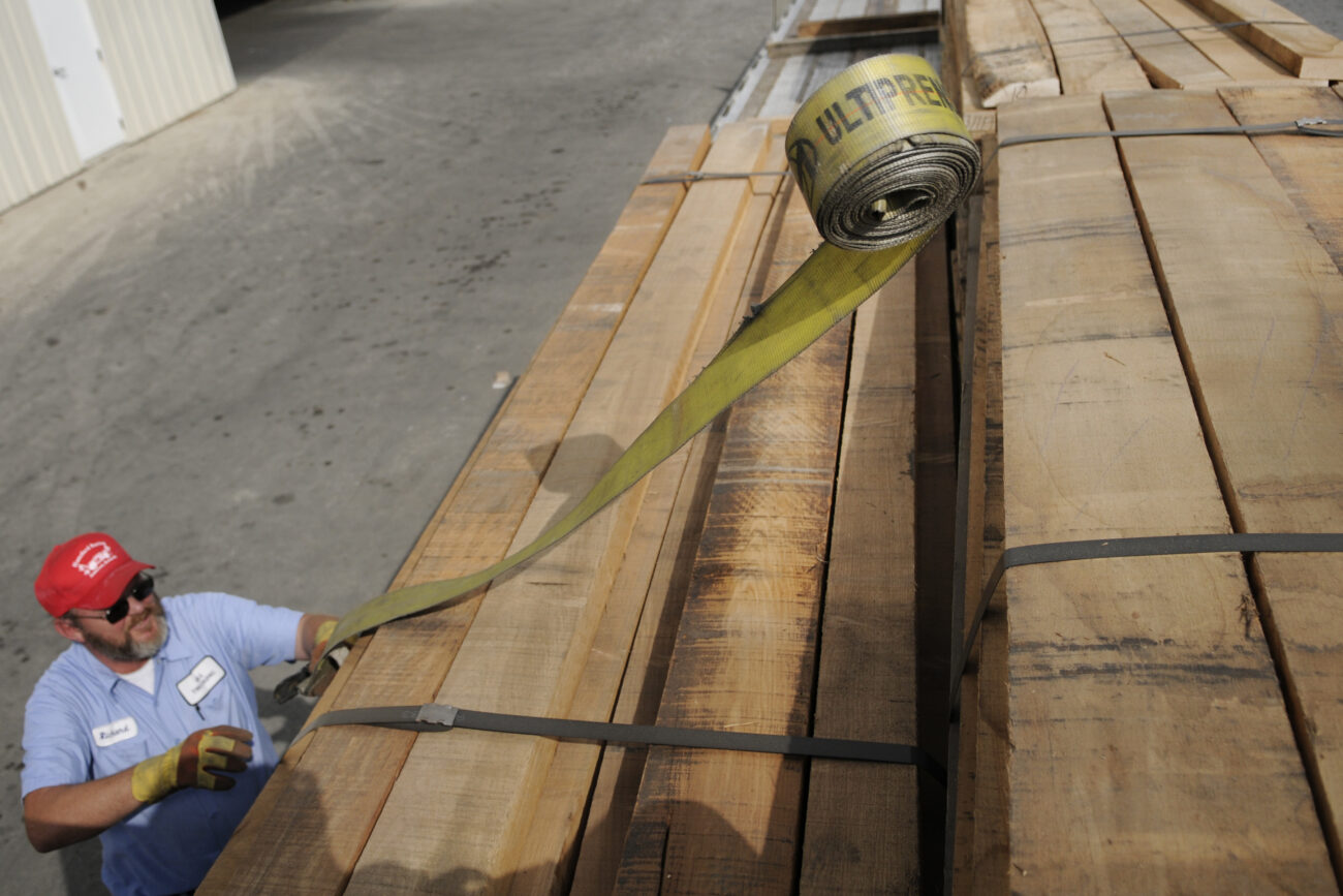 Richard Walls, a driver for Gill Trucking who works with Begley Lumber often, tosses a tie-down rope over packs of lumber before driving the load to Tennessee Friday afternoon.