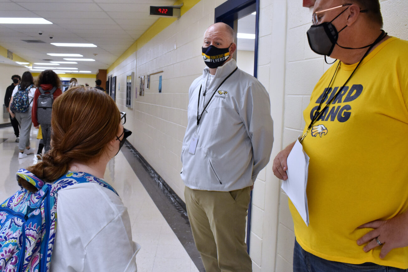 During class change, Principal Chris Tracy talks with student Aubree Fuller and girls basketball coach Joey Thacker at Franklin County High School in Frankfort, Kentucky, on Friday, Oct. 15, 2021.