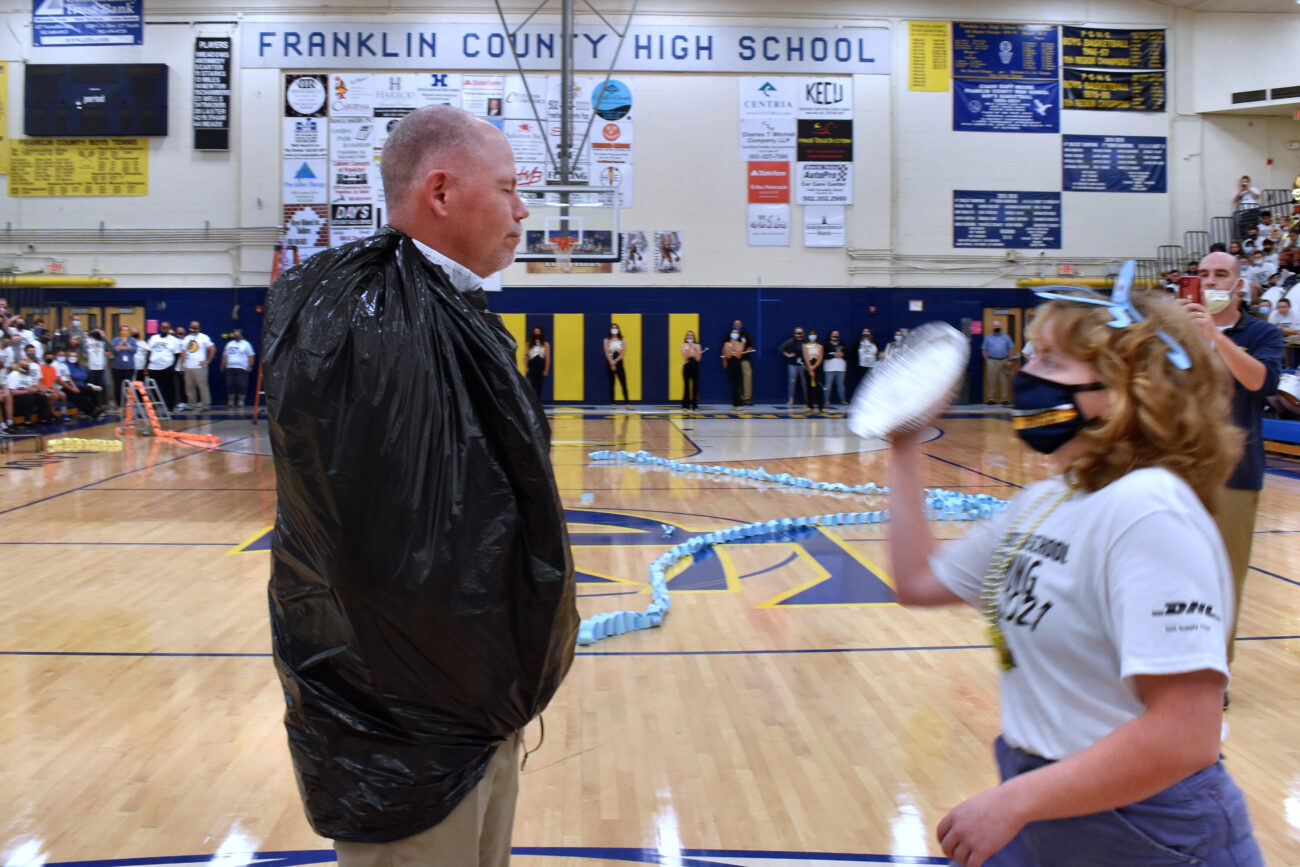 Student Katherine Nolan, who won a student led raffle for the chance to throw a pie in the face of Principal Tracy, winds up for the throw at the homecoming pep rally on Friday, Oct. 15, 2021.