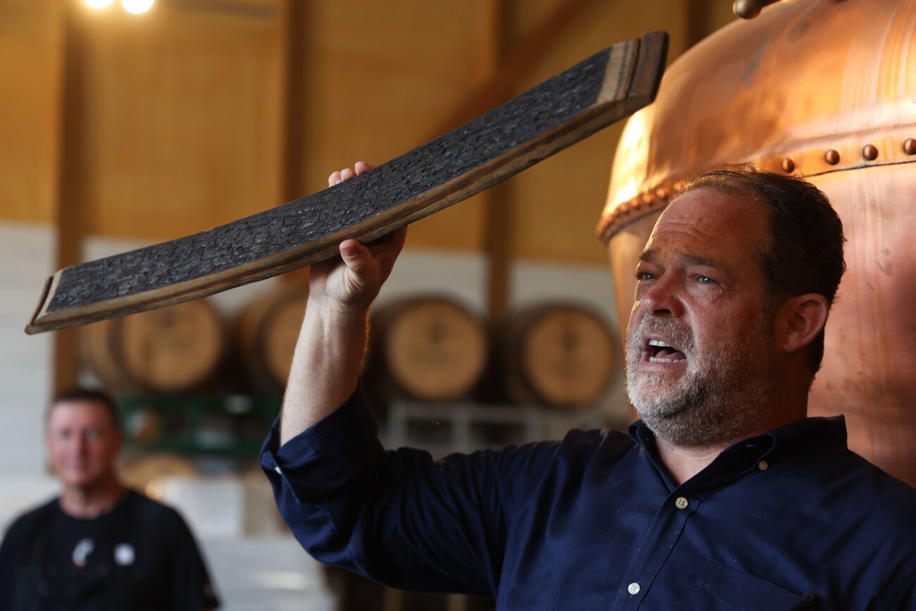 Walter Zausch, owner of Three Boys Farm Distillery, holds up a piece of a bourbon barrel while giving a tour on Thursday, Oct. 14, 2021, at Three Boys Farm Distillery in Franklin County, Kentucky. Photo by Jack Weaver