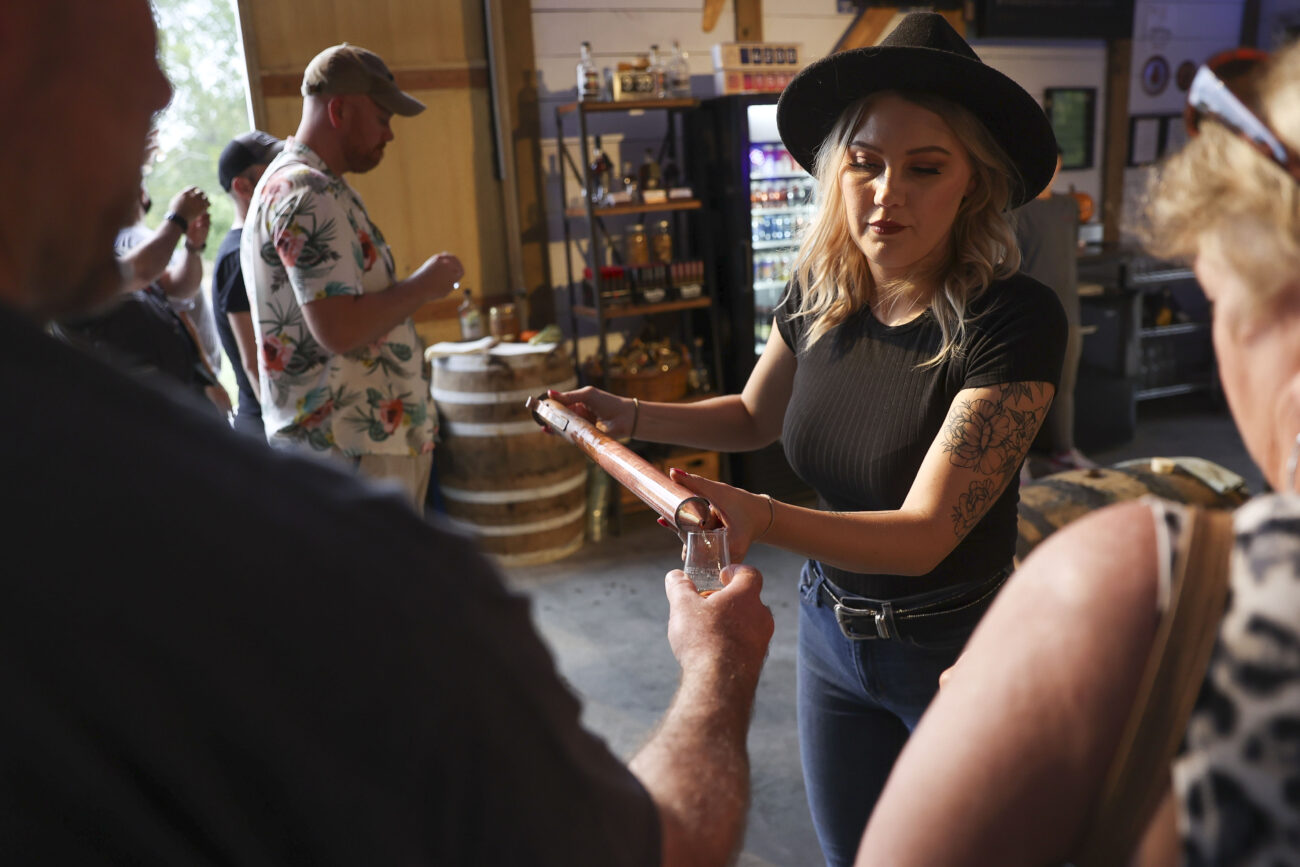 Ashleigh Kerby uses a bourbon thief to pour bourbon in a glass for a customer to sample on Wednesday, Oct. 13, 2021, at Three Boys Farm Distillery in Franklin County, Kentucky. Customers are given five samples straight from the barrel. Photo by Jack Weaver