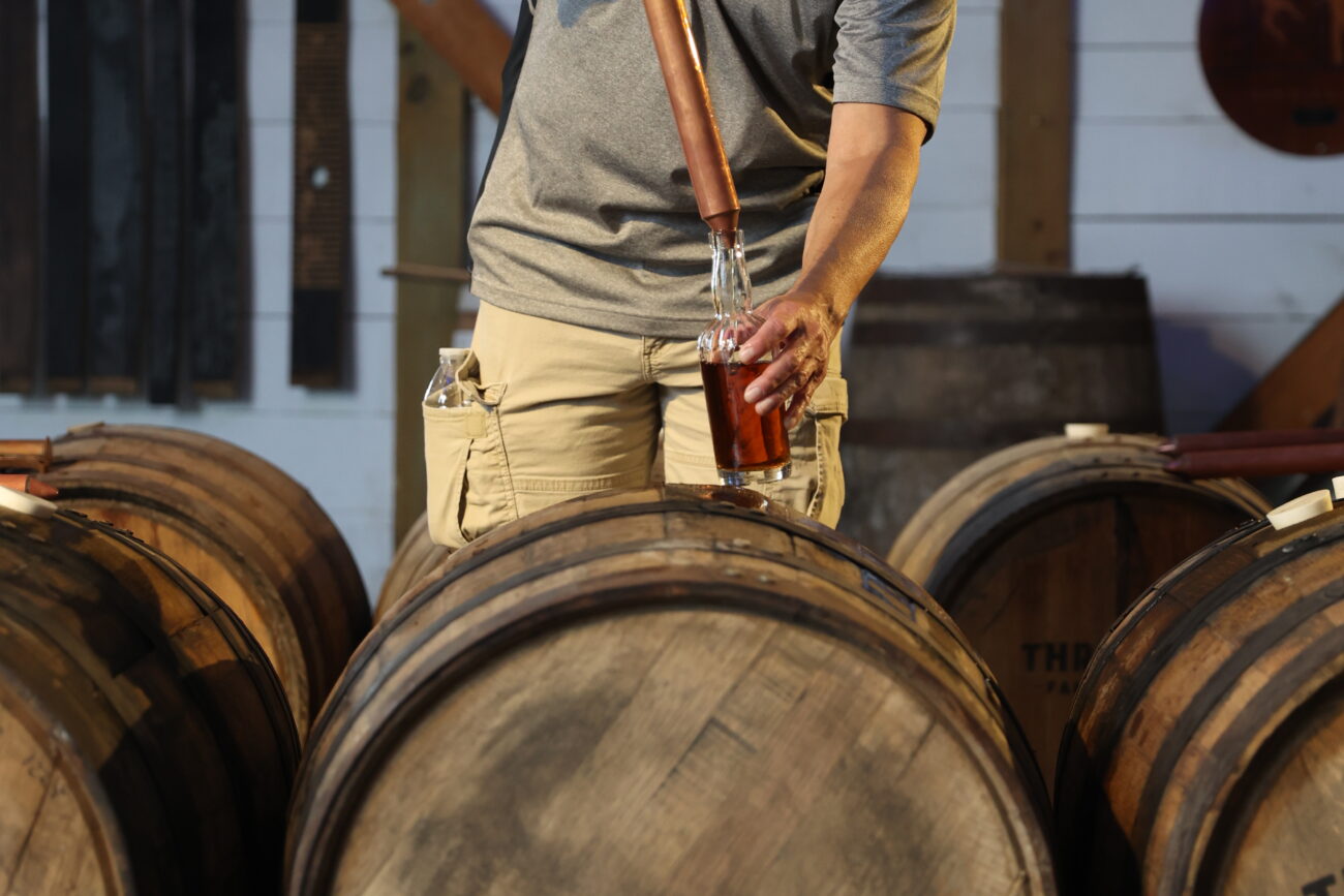 A customer fills a bottle with bourbon on Wednesday, Oct. 13, 2021, at Three Boys Farm Distillery in Franklin County, Kentucky. Photo by Jack Weaver