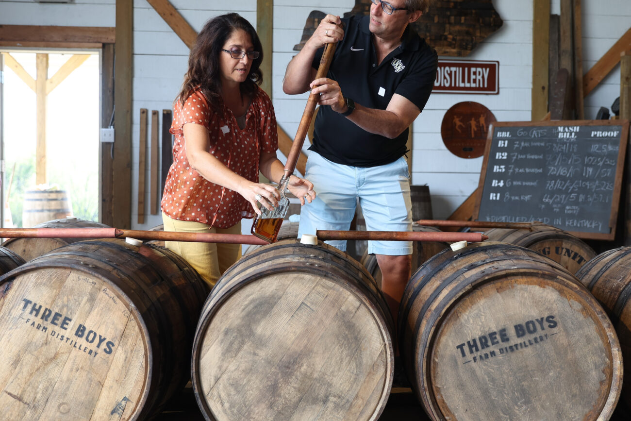 Katerina and George Papaioanou fill a bottle with bourbon on Thursday, Oct. 14, 2021, at Three Boys Farm Distillery in Franklin County, Kentucky. Photo by Jack Weaver