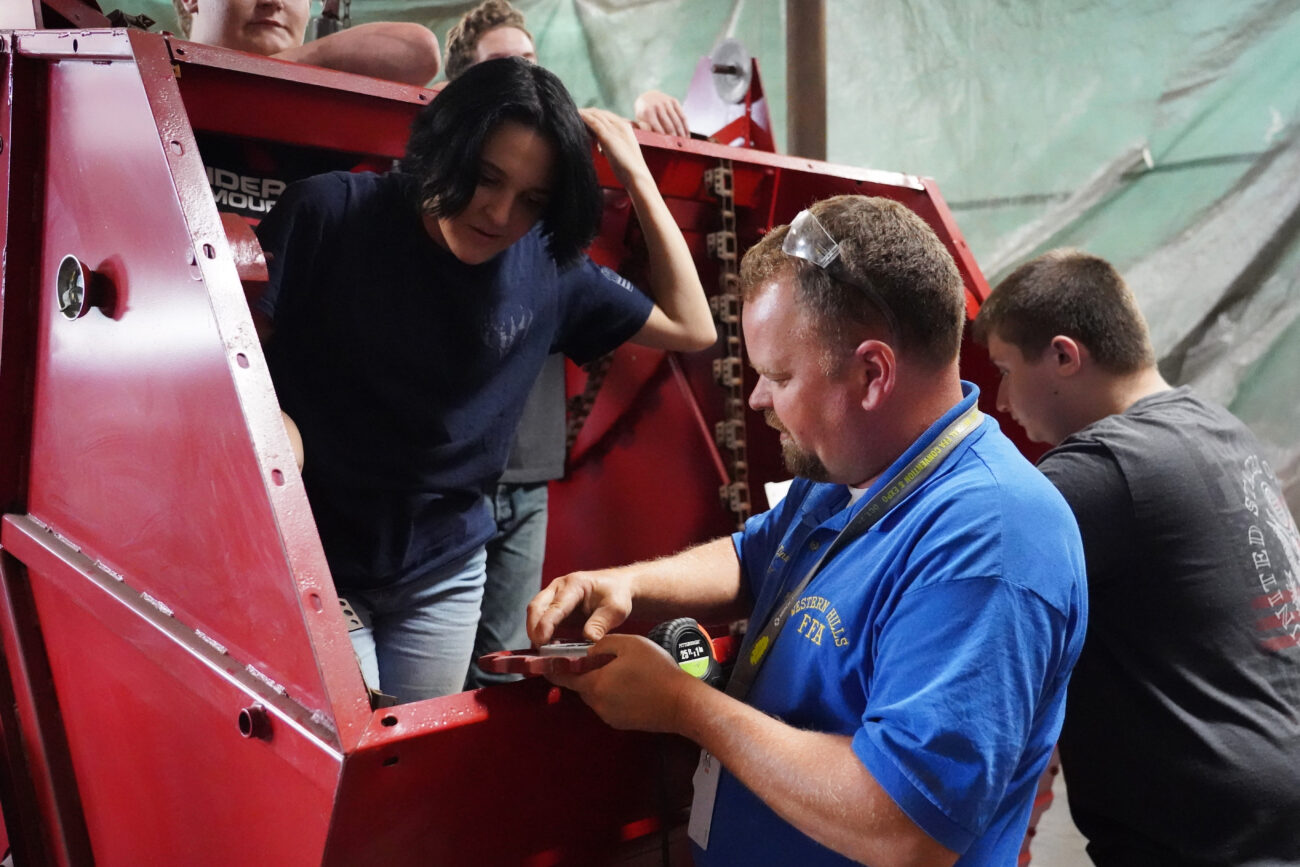 J.R. Zinner shows his students that the pieces they thought were missing for rebuilding the combine are actually stuck underneath a layer of paint on the gears during Zinners agricultural mechanics class on Thursday, Oct. 14, 2021, at Western Hills High School in Frankfort, Ky. Earlier Dinner traveled to Shelby County in order to pick up the parts they had ordered the previous day only to find the missing parts left on the gears. Photo by Kaitlyn Skaggs