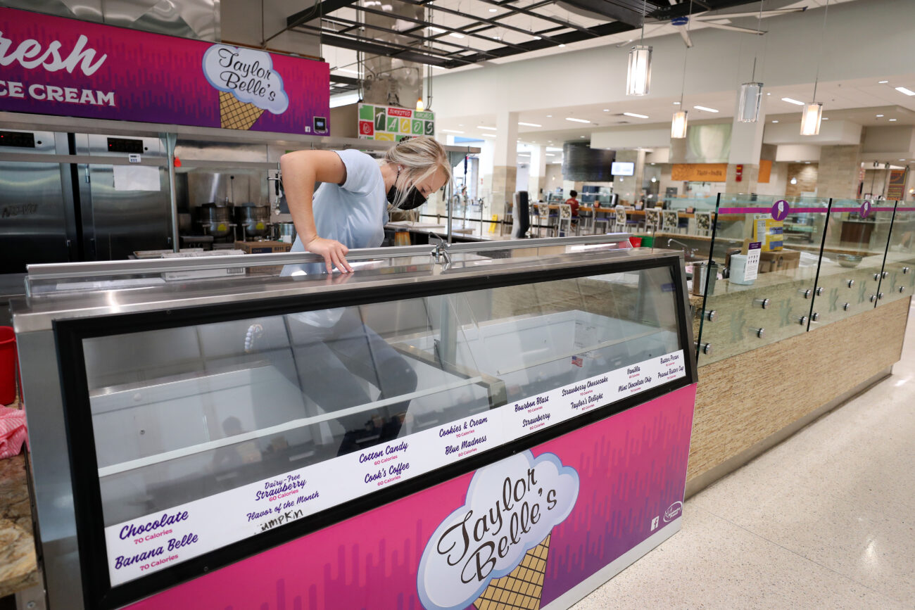 Taylor Cook climbs out of her freezer on Thursday, Oct. 14, 2021 at The 90 on the University of Kentucky. Once a month, Cook drives to Lexington to defrost the freezer and restock the on-campus location with her latest flavors. Taylor Belles also has locations at Eastern Kentucky University, Centre College, Midway University and the University of Louisville.