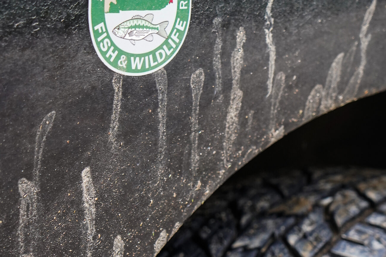 Mud and dirt streak the passenger side and tire of James Brace’s truck on Friday, Oct. 15, 2021, in Frankfort, Kentucky. Brace drove around Franklin County, checking for fishing license violations, although the rain deterred most fishermen. “Nothing’s happening in this rain,” Brace said.