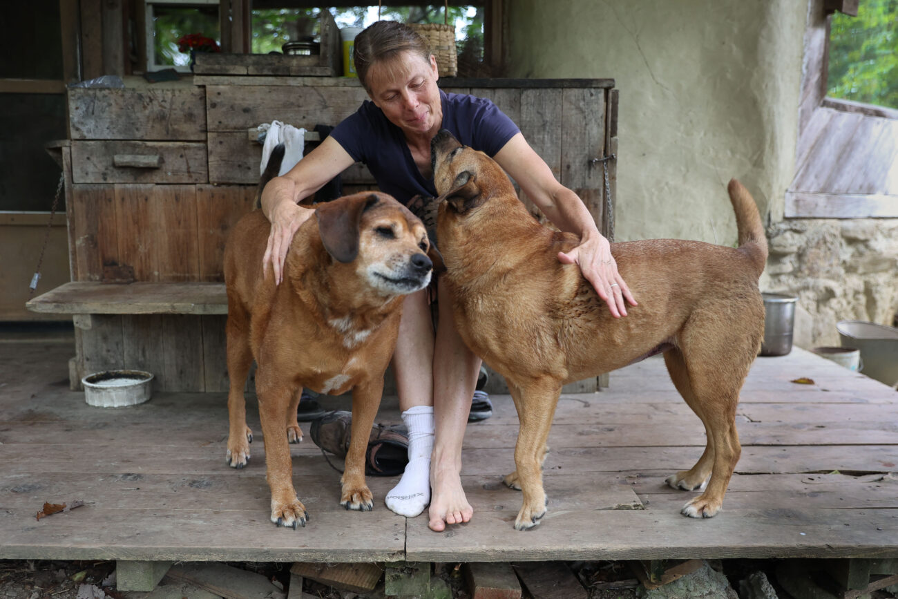 Chris Schimmoeller pets her two dogs, Shiloh (left) and Lucy, on her porch on Thursday, Oct. 14, 2021, at her home off of Mount Vernon Road in Frankfort, Kentucky. Photo by Jack Weaver