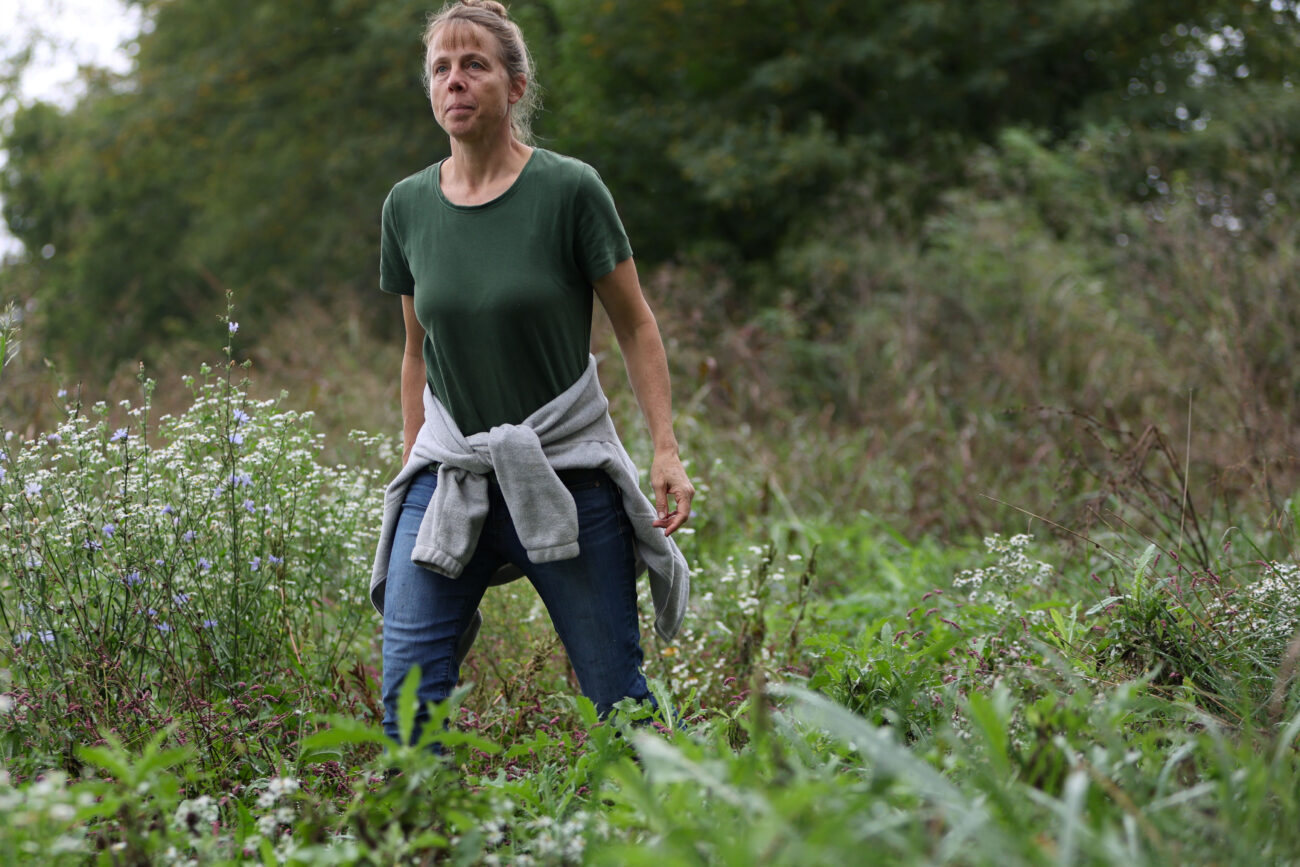 Chris Schimmoller walks through a field while giving advice about invasive plants to a property owner new to Kentucky on Friday, Oct. 15, 2021, at a property in Fayette County, Kentucky. Schimmoeller, who lives her life off the grid, began Remove Invasives Partnership, which helps property owners understand how to remove invasive plants, in 2017 after years of seeing invasives while driving to town. Photo by Jack Weaver