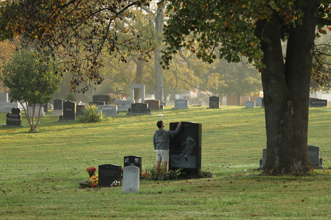 Jacob Graves has a moment with the grave of a lost friend at the Frankfort Cemetery in Frankfort, Ky. on Thurday, Oct. 14, 2021 (Photo by Martha McHaney).