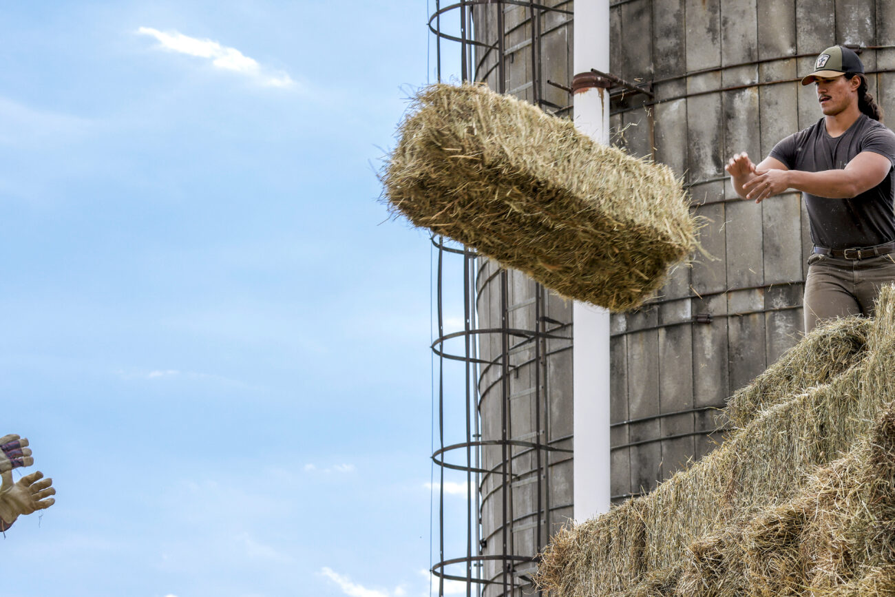 Kentucky State University farm tech and research assistant McKinley Stonewall unloads a wagon full of hay bales with his co-worker in preparation for the farm’s goats in Frankfort, KY, on Oct. 6, 2022.