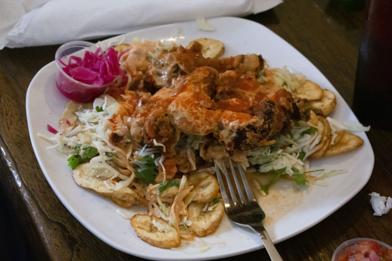 A plate of pollo con tajadas sits on a customer’s table at Mami Monchita’s Honduran restaurant in Frankfort, Kentucky, during lunch on Friday, October 7, 2022. The dish is a popular Honduran street food, featuring fried chicken, plantains, cabbage, tomato sauce and pickled onions. Photo | Nyah Leveretter