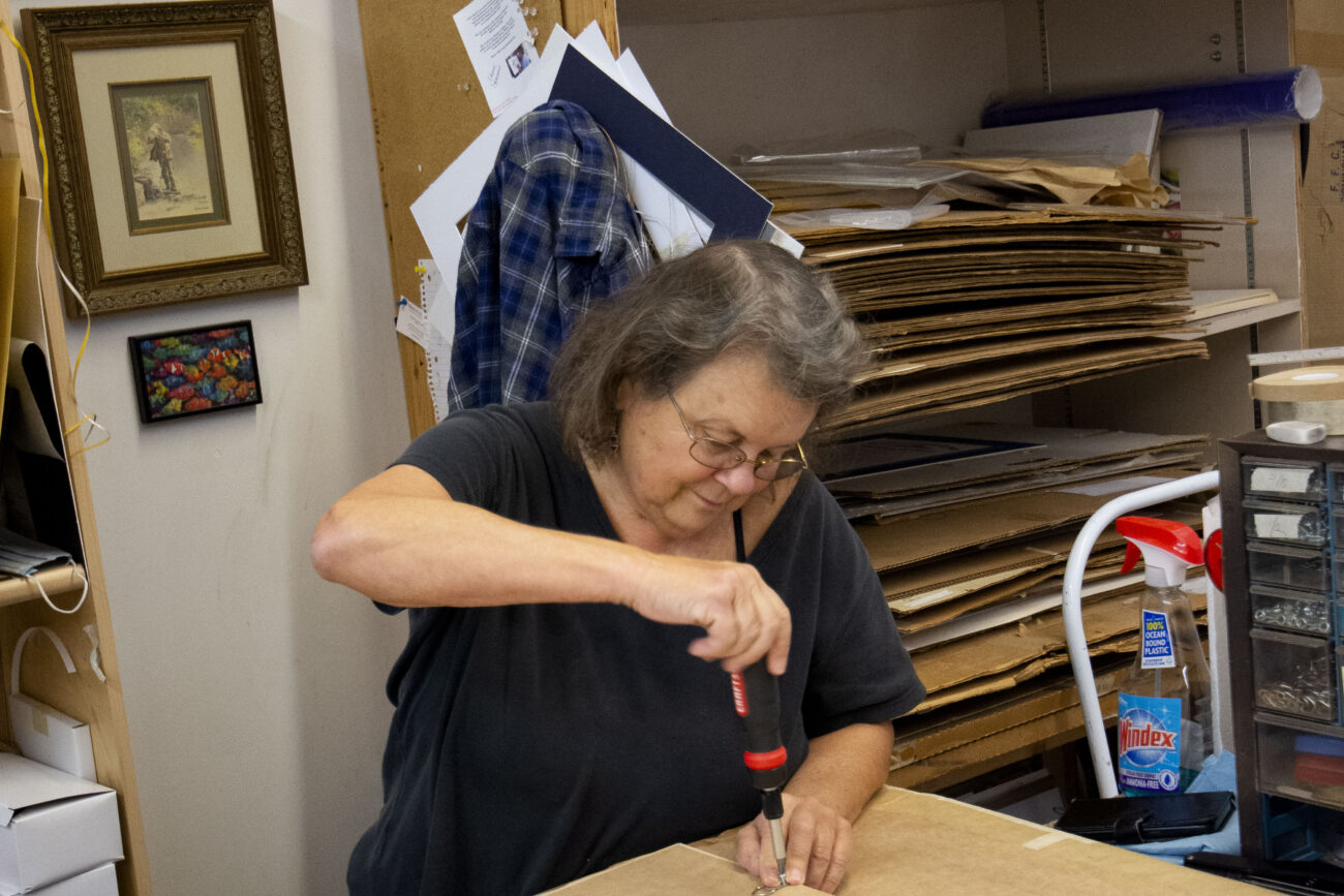 Leslie Shane, a designer at Jessie’s Art Gallery and Custom Framing, places backing clips on a custom picture frame on Thursday, October 6, 2022, in Frankfort, Kentucky. Photo | Nyah Leveretter