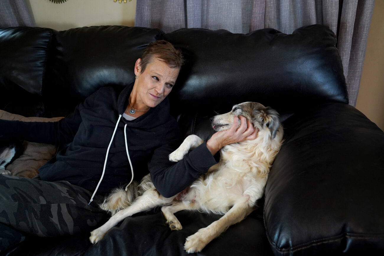 Jenny Hurst gives her rescue dog Possum a head scratch on the couch in her living room in Frankfort, Ky. on Saturday, Oct. 8, 2022. Possum was brought to Franklin Veterinary Clinic, where Hurst works, when he was a puppy. Hurst took a liking to him and consequently adopted him. Photo by Carter Skaggs
