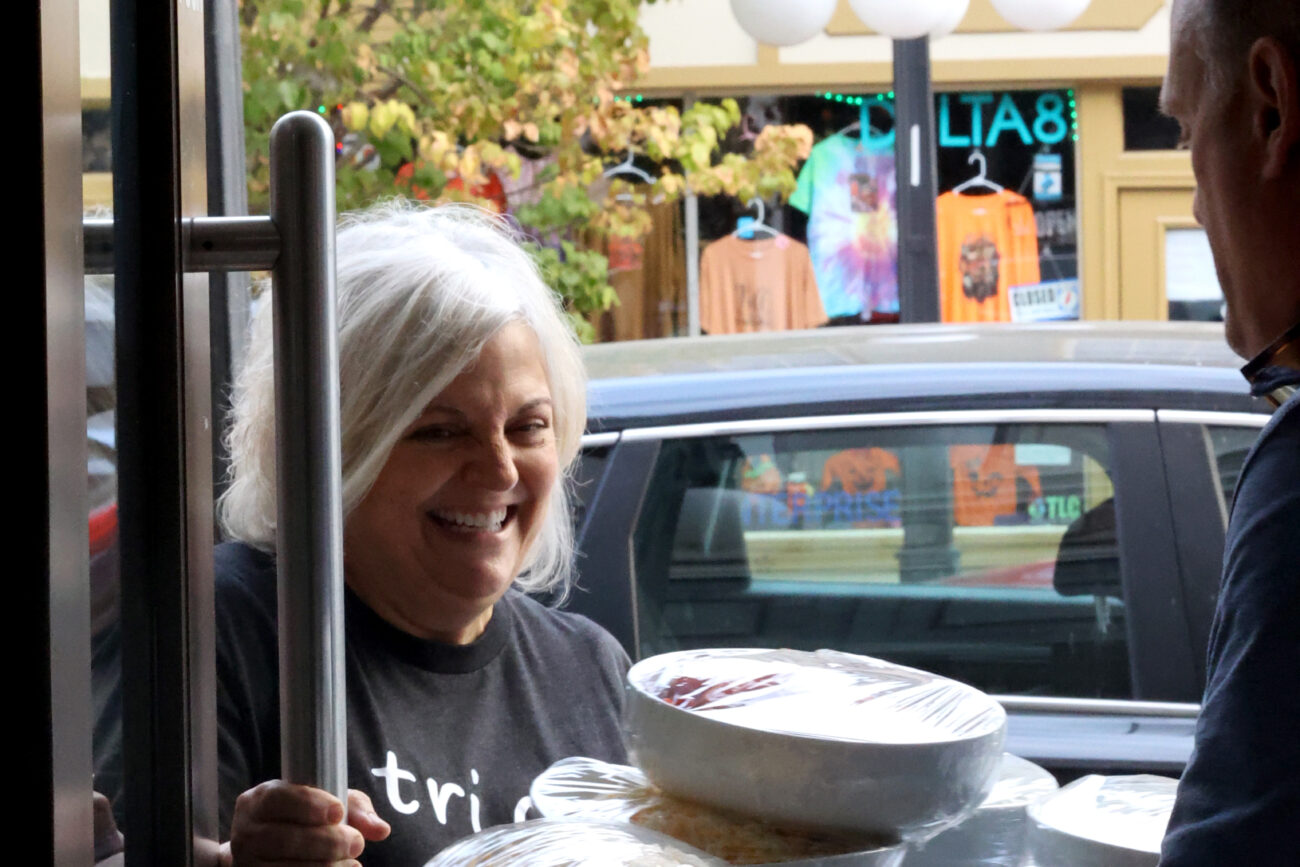 Beth Greenwell Carter holds open a door for one of her customers in B’s Bakery in Frankfort KY, on Oct. 7, 2022.